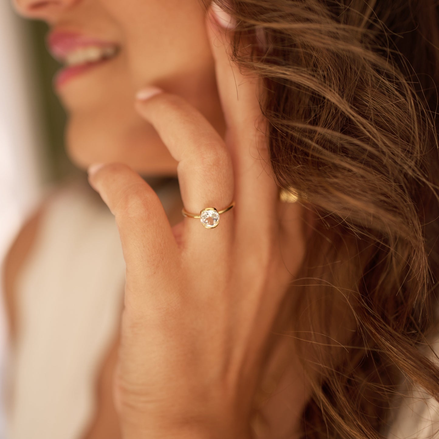 Close-up of a woman wearing Ruhi Ring with a white topaz stone on her finger