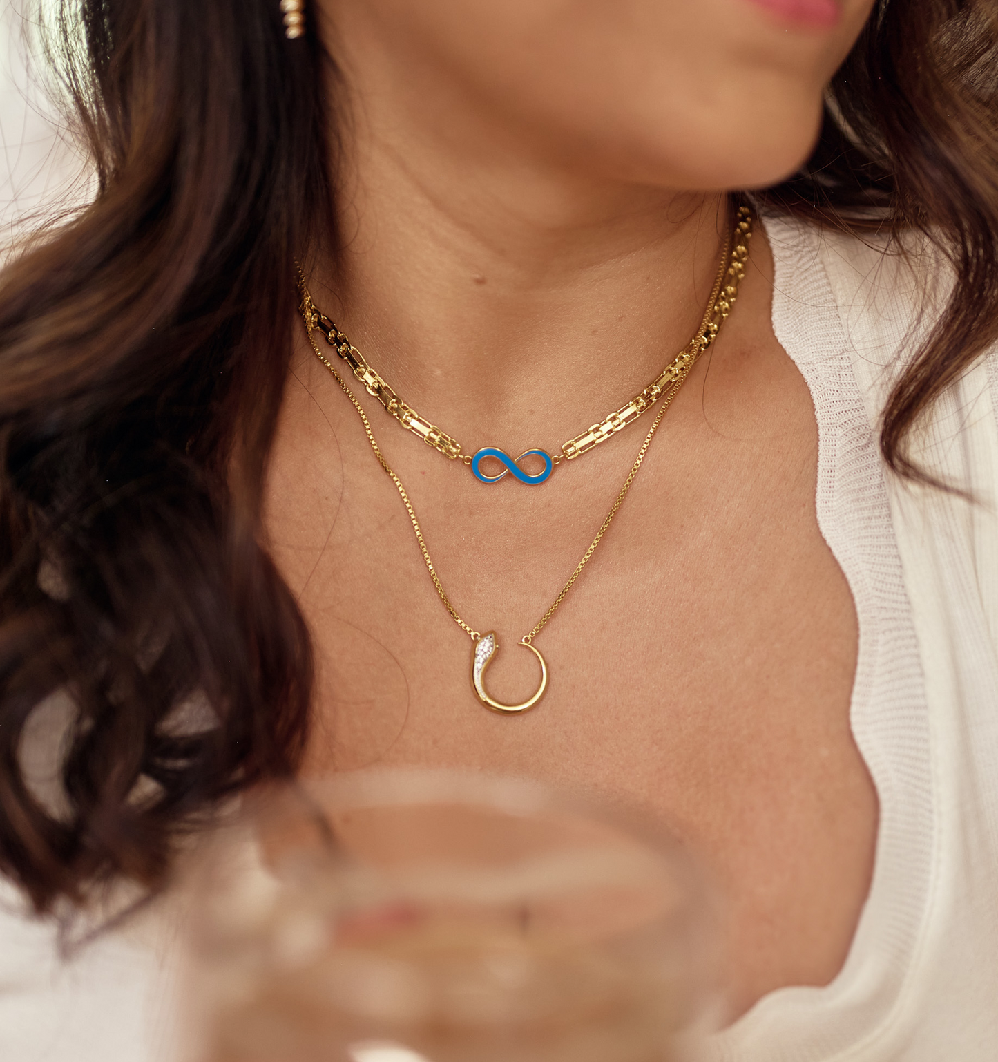 Oroha Necklace gold chain with white topaz pendant worn on woman's neck