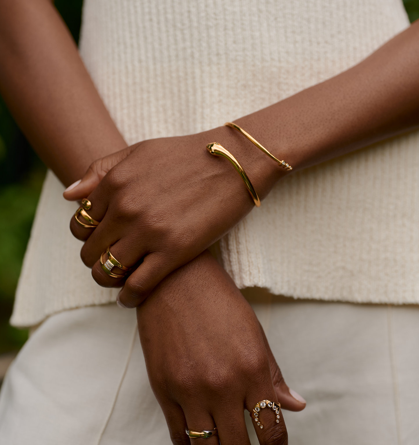Gold Sarpa Cuff with sculptural serpent design on wrist and gold rings on fingers