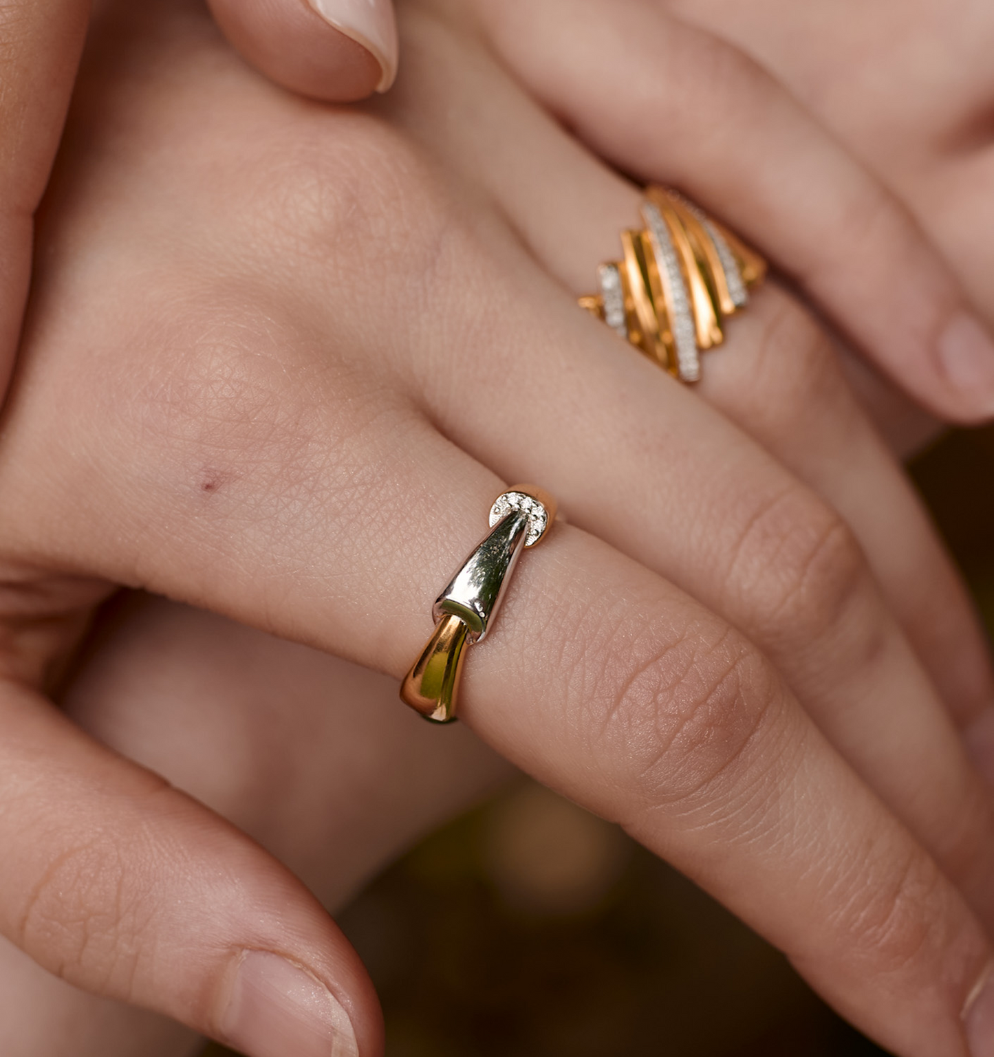 Close-up of Veera Ring with gold and silver segments and five lab-grown diamonds on a finger