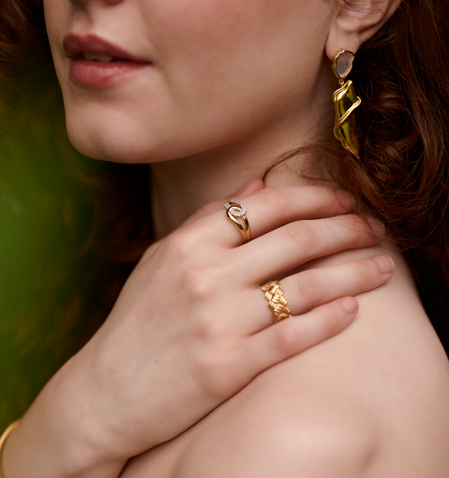 Close-up of woman's hand wearing Sahaya Ring with white topazes and gold intertwining paths