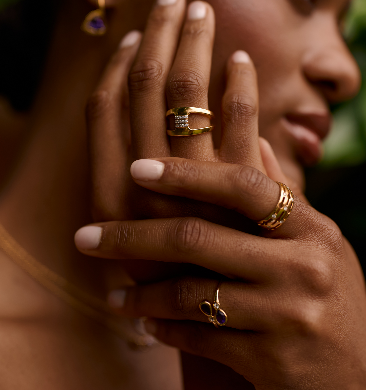 Close-up of hand wearing gold Setu Ring with white topaz detail symbolizing clarity and connection