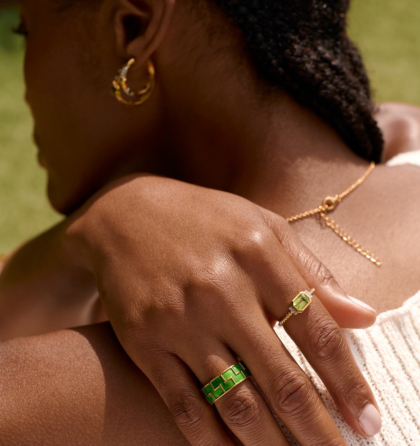 Arohi Ring gold with green stones on woman's hand close-up