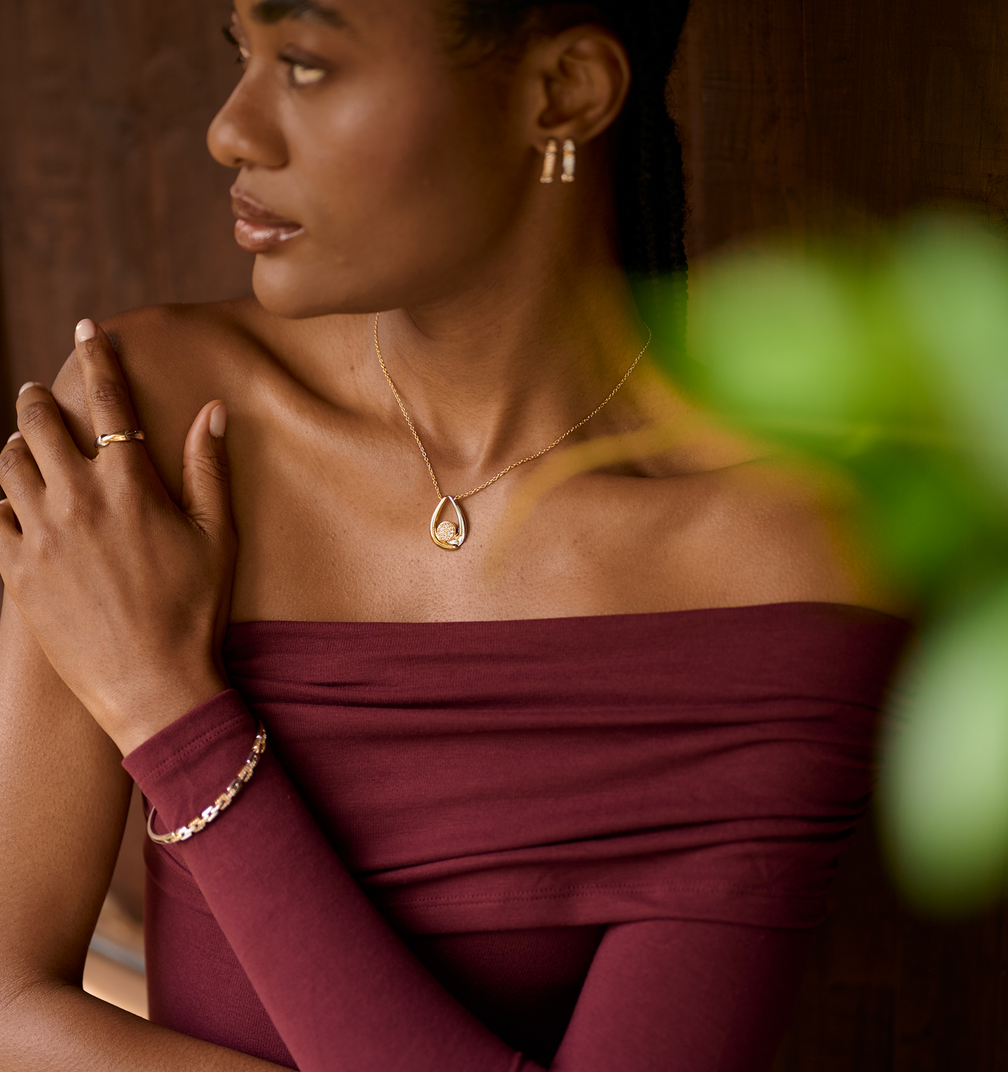 Woman wearing Antara Necklace with gold and silver arcs around white topaz cluster