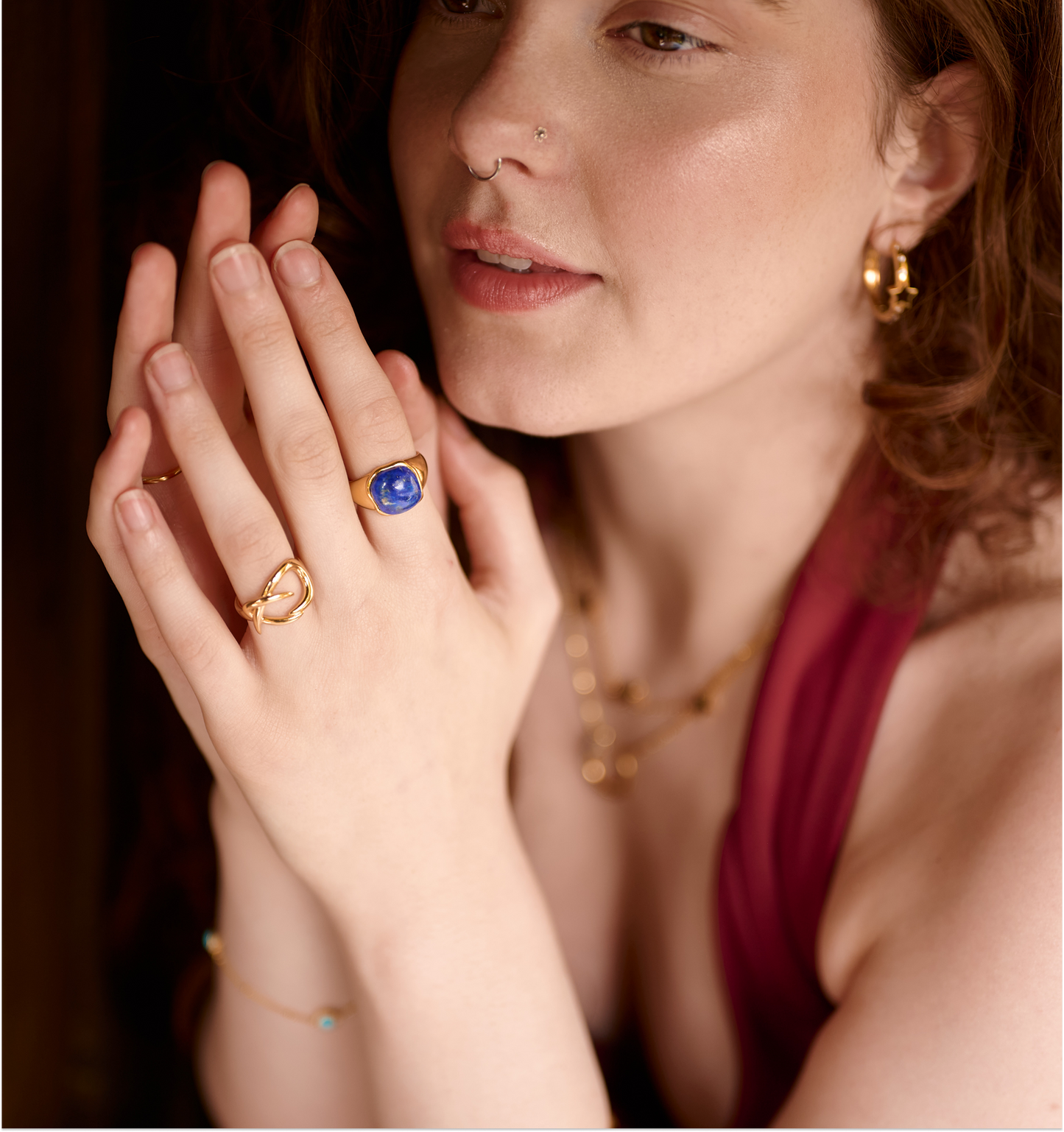 Close-up of a woman wearing the gold Karvat Ring with curves on her finger, showcasing its elegant and sculpted design