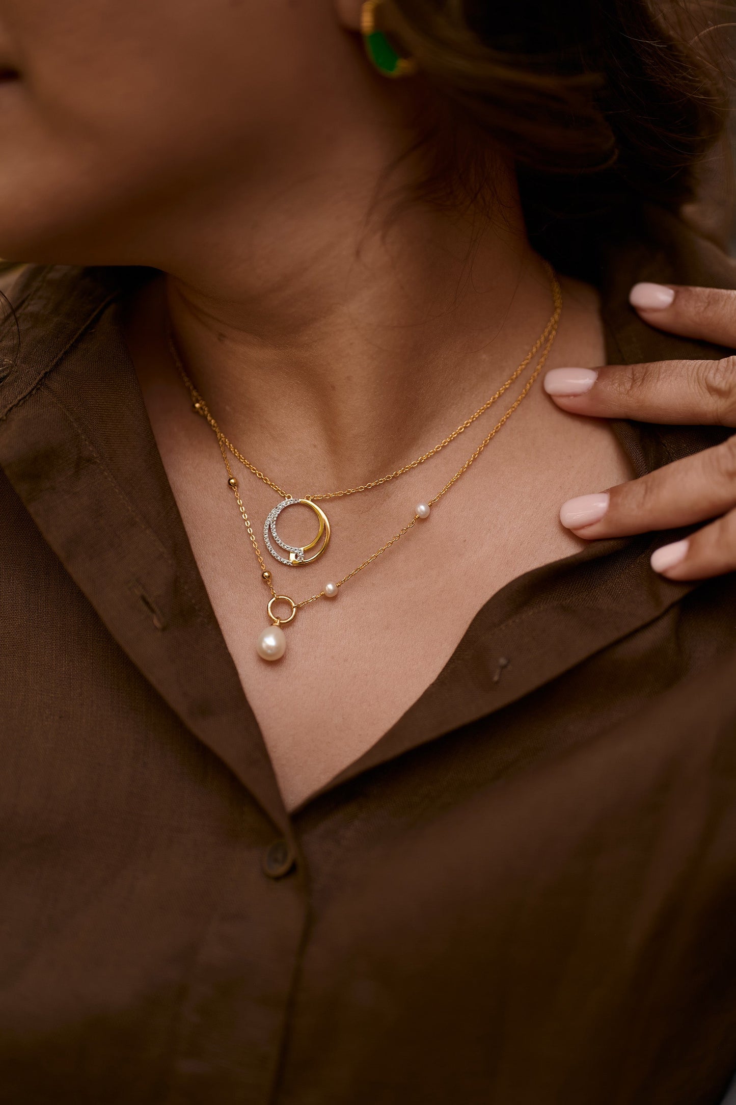 Argha Necklace featuring gold circle with descending pearl and delicate chain on woman’s neck