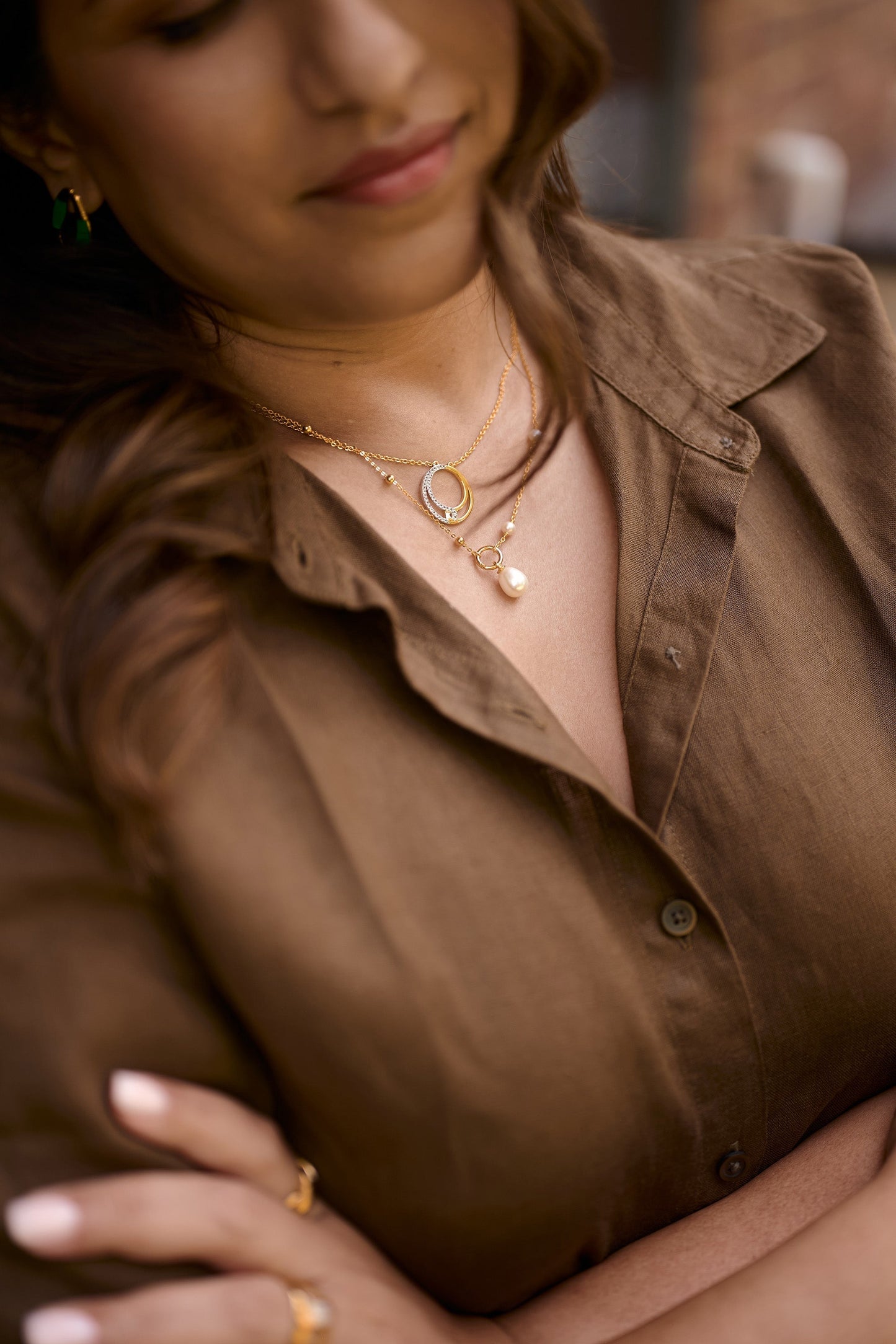 Close-up of woman wearing Argha Necklace with golden circle and pearl pendant
