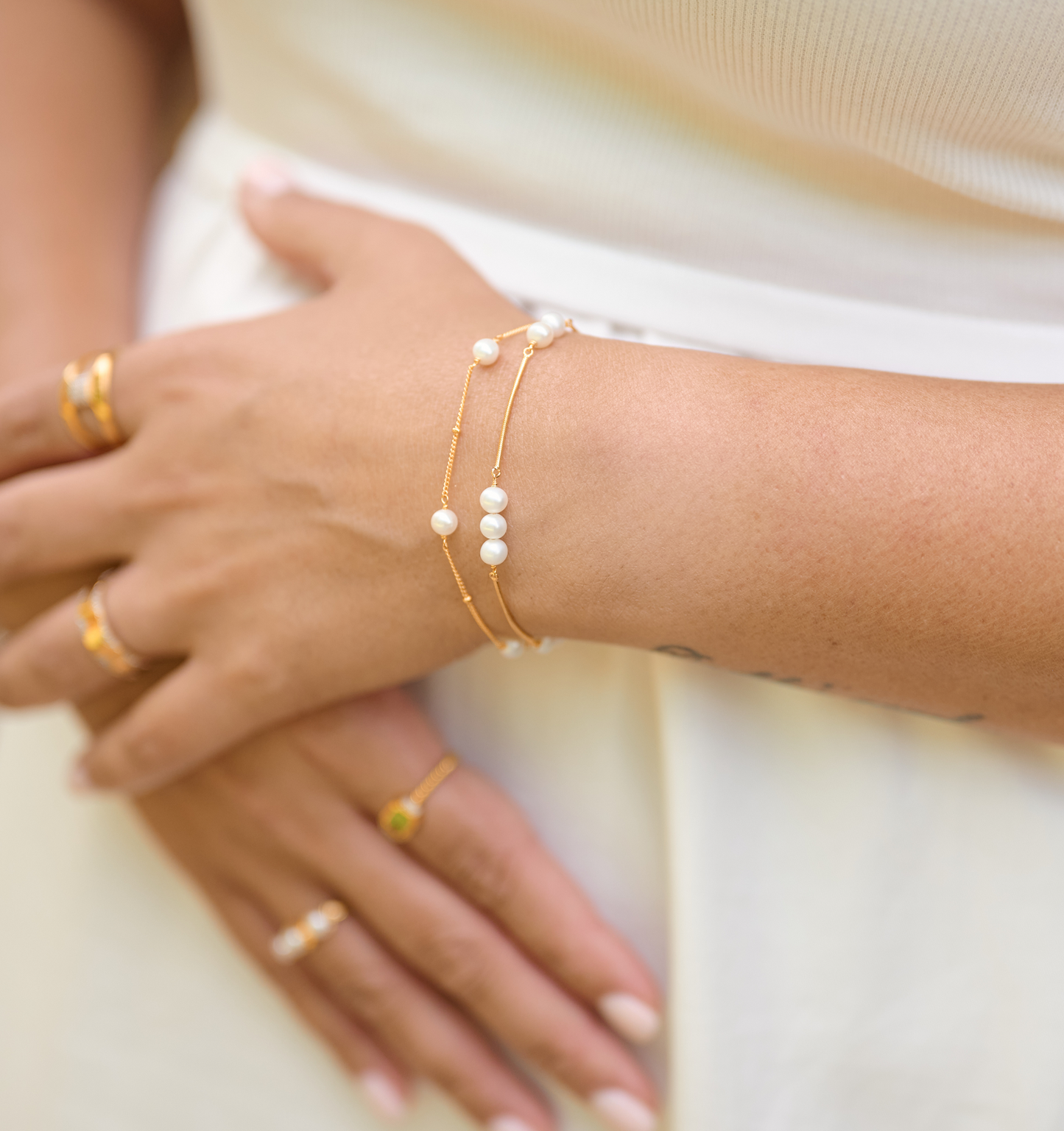 Close-up of wrist wearing Shanai Bracelet with six pearls on delicate gold chains