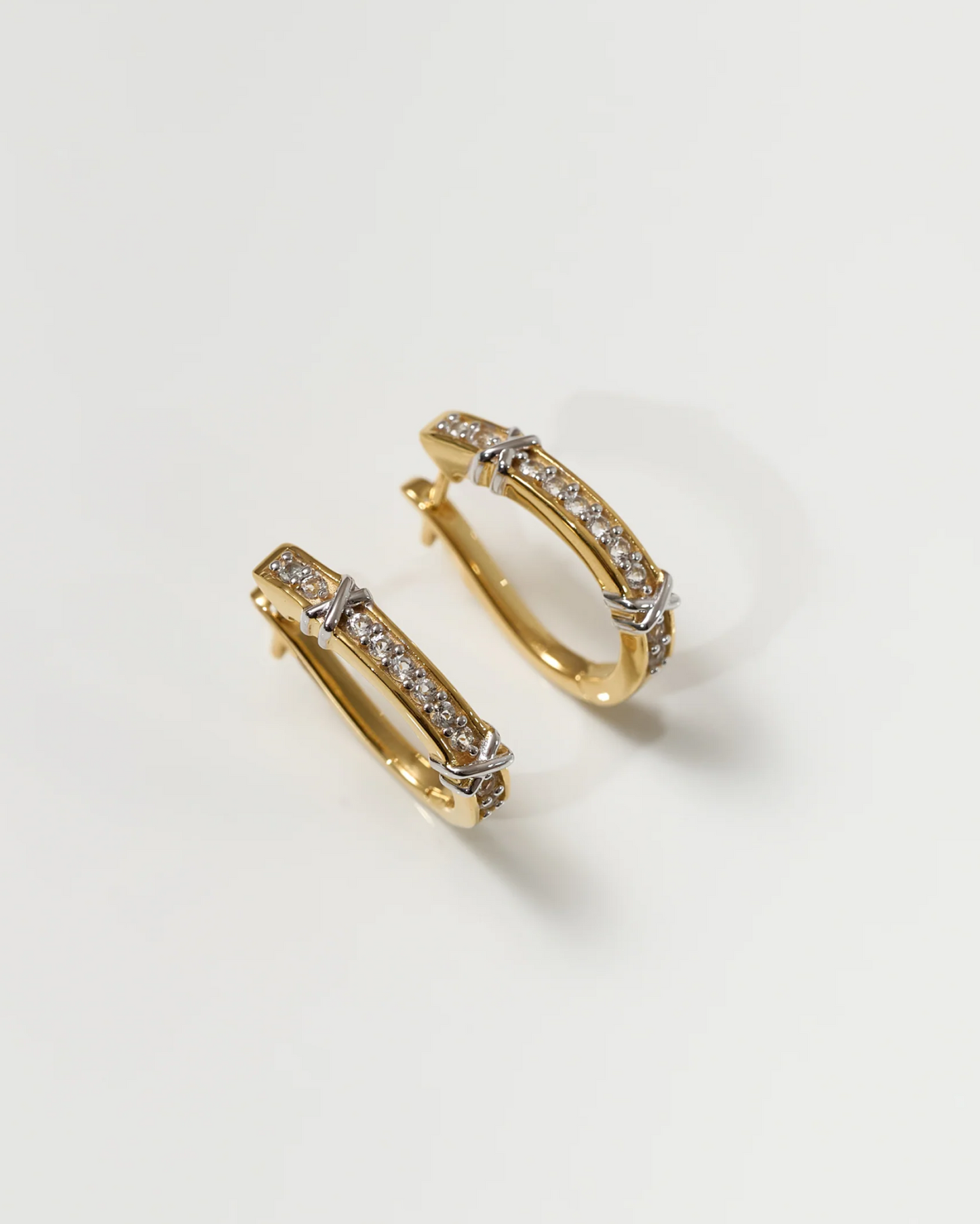 Gold Aarvi Hoops earrings with pavé white topaz stones on a neutral background