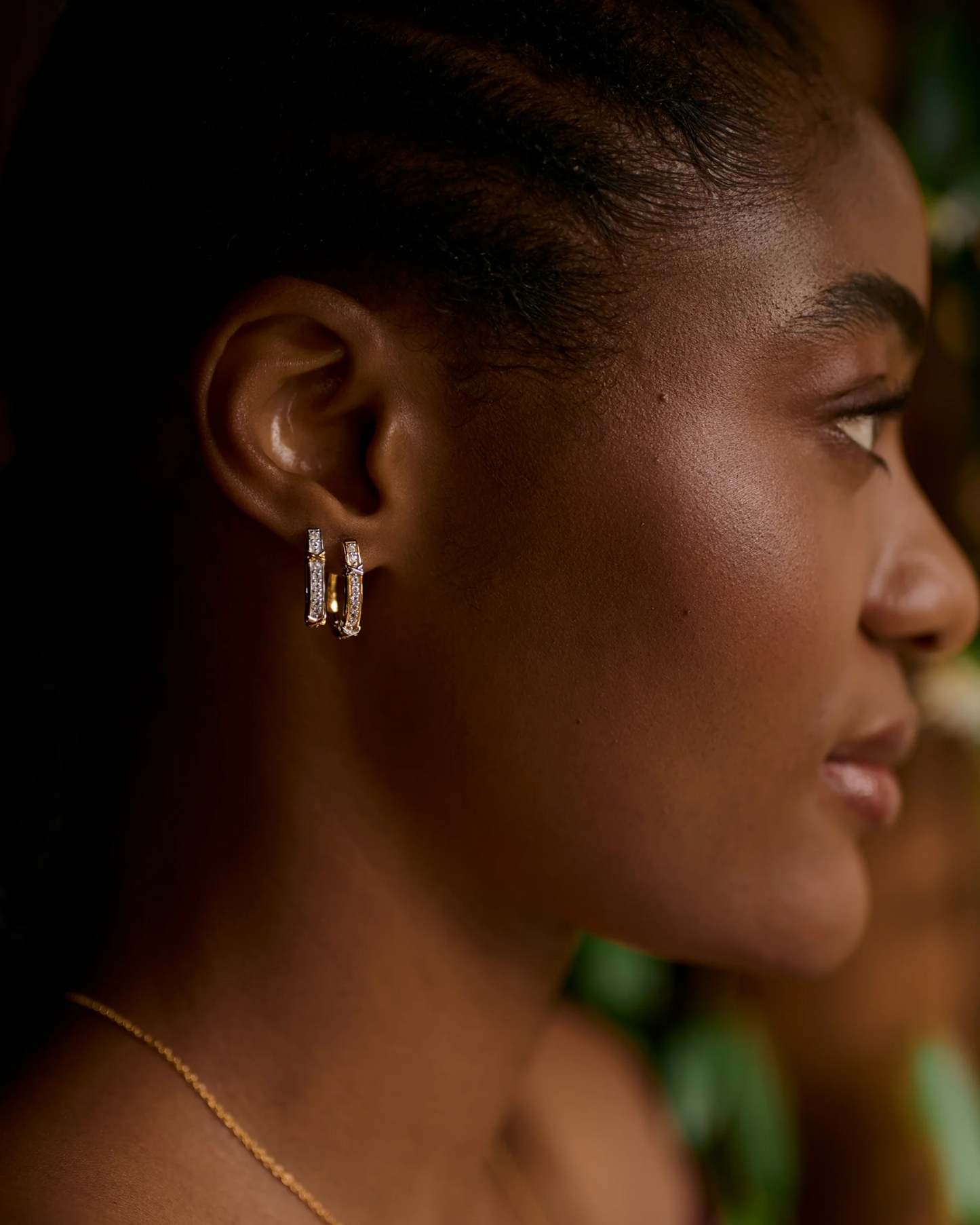 Close-up of a woman wearing gold Aarvi Hoops earrings with pavé white topaz stones.