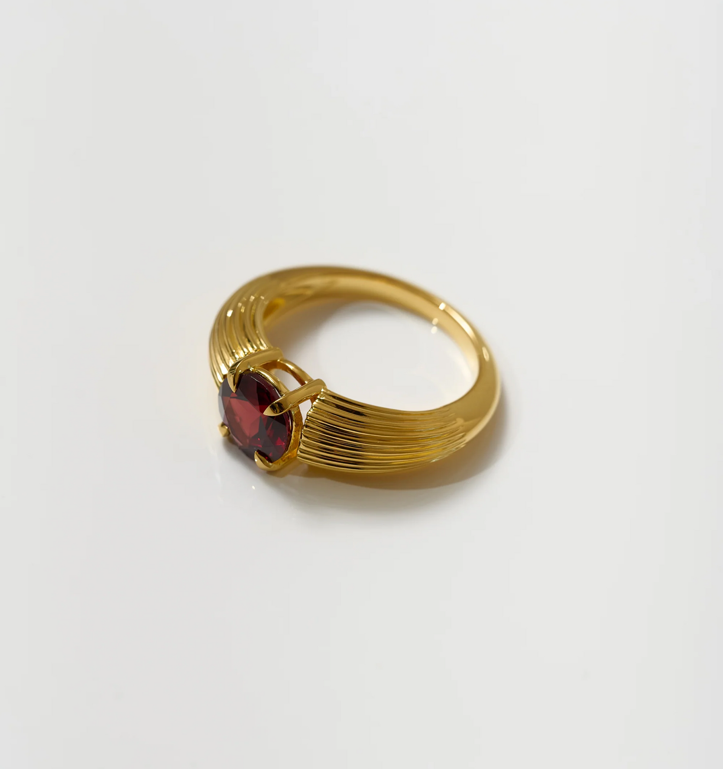 Ishaya Ring with deep red garnet set in bold gold band symbolizing fierce love and inner power