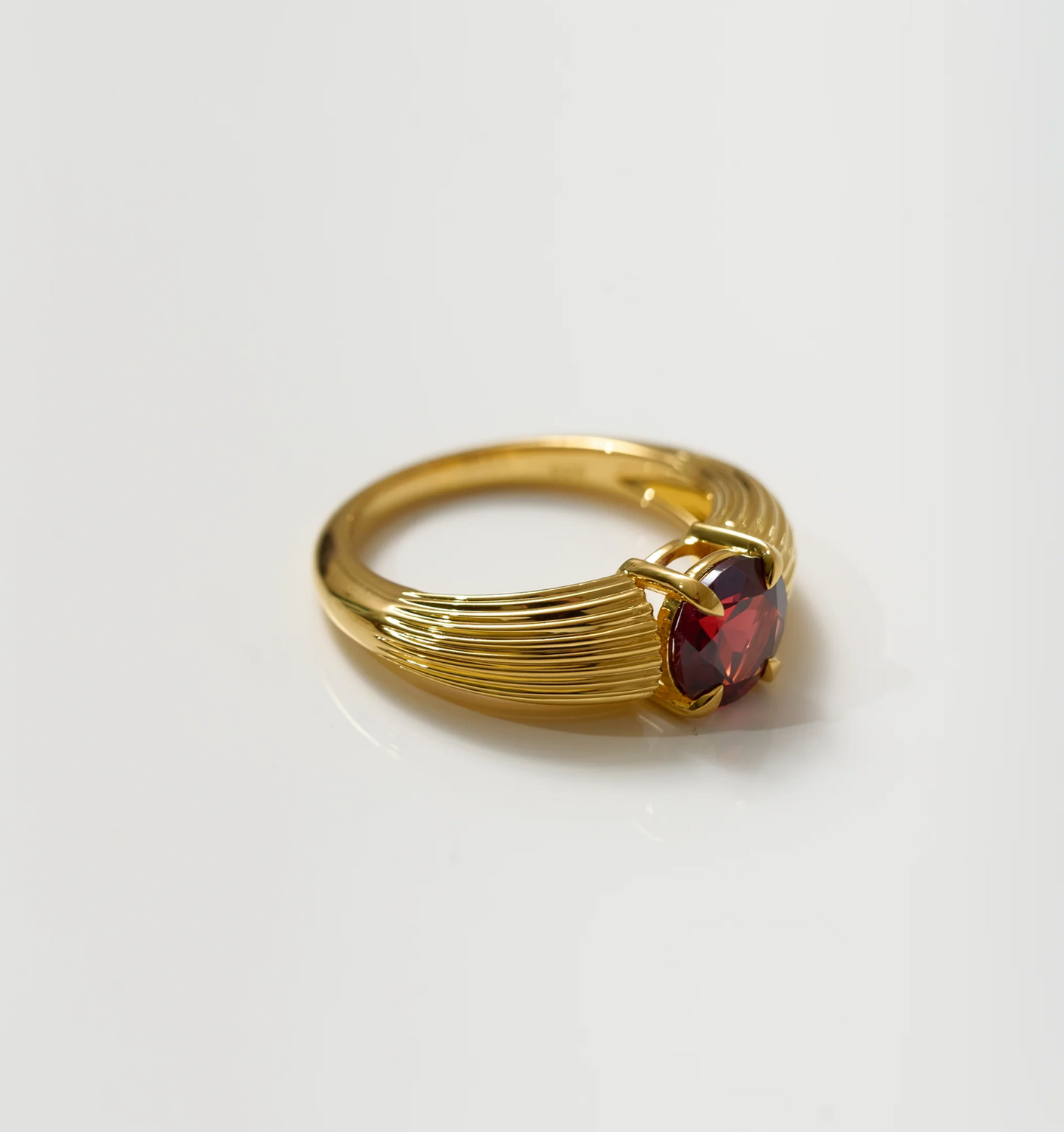 Ishaya Ring with deep red garnet set in bold gold band showcasing fierce love and inner power