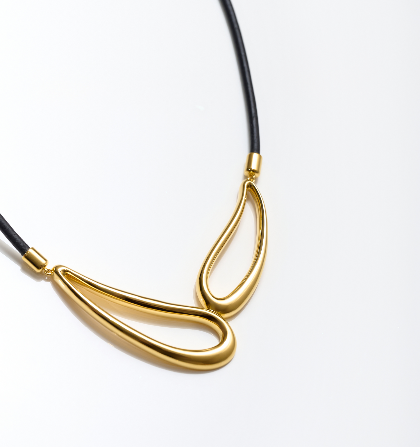 Saha Necklace elegant twin sculpted gold forms on black cord reflecting connection and balance