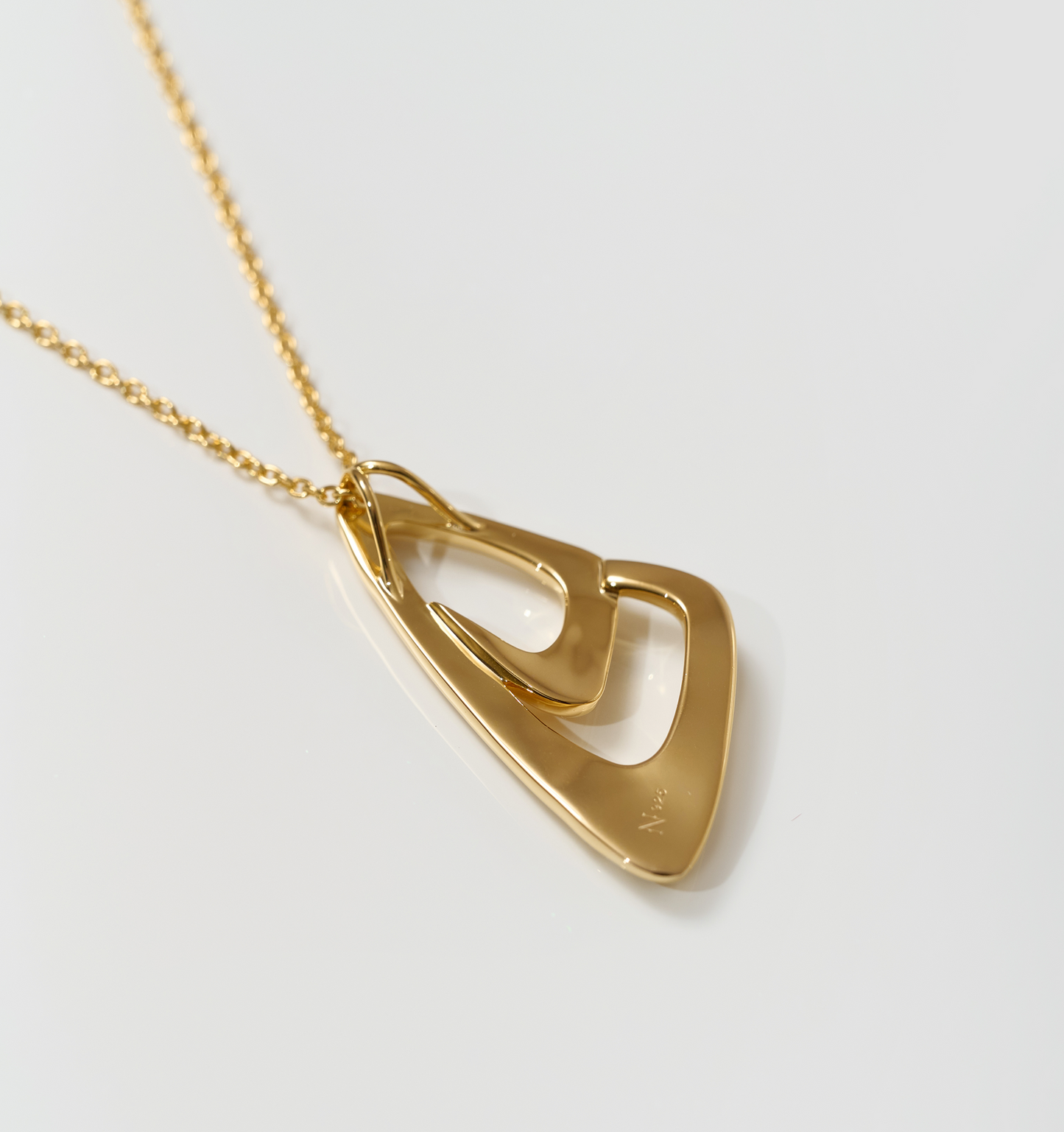 Aavrit Necklace gold pendant with elegant curved geometric design on chain