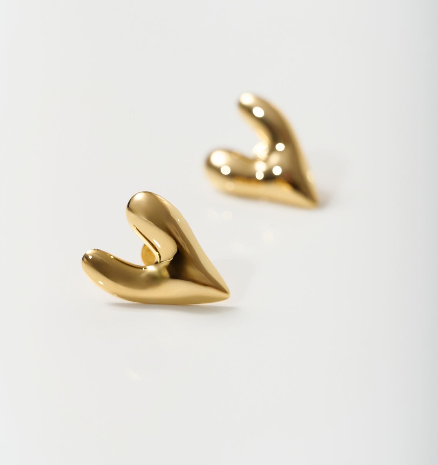 Gold-toned silver Avara Earrings with uneven, sculptural heart-shaped design and raw organic finish