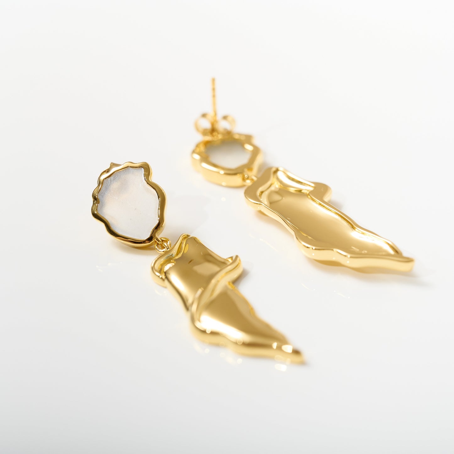 Thalena Earrings with gold sculpted design and moonstone accents on white background