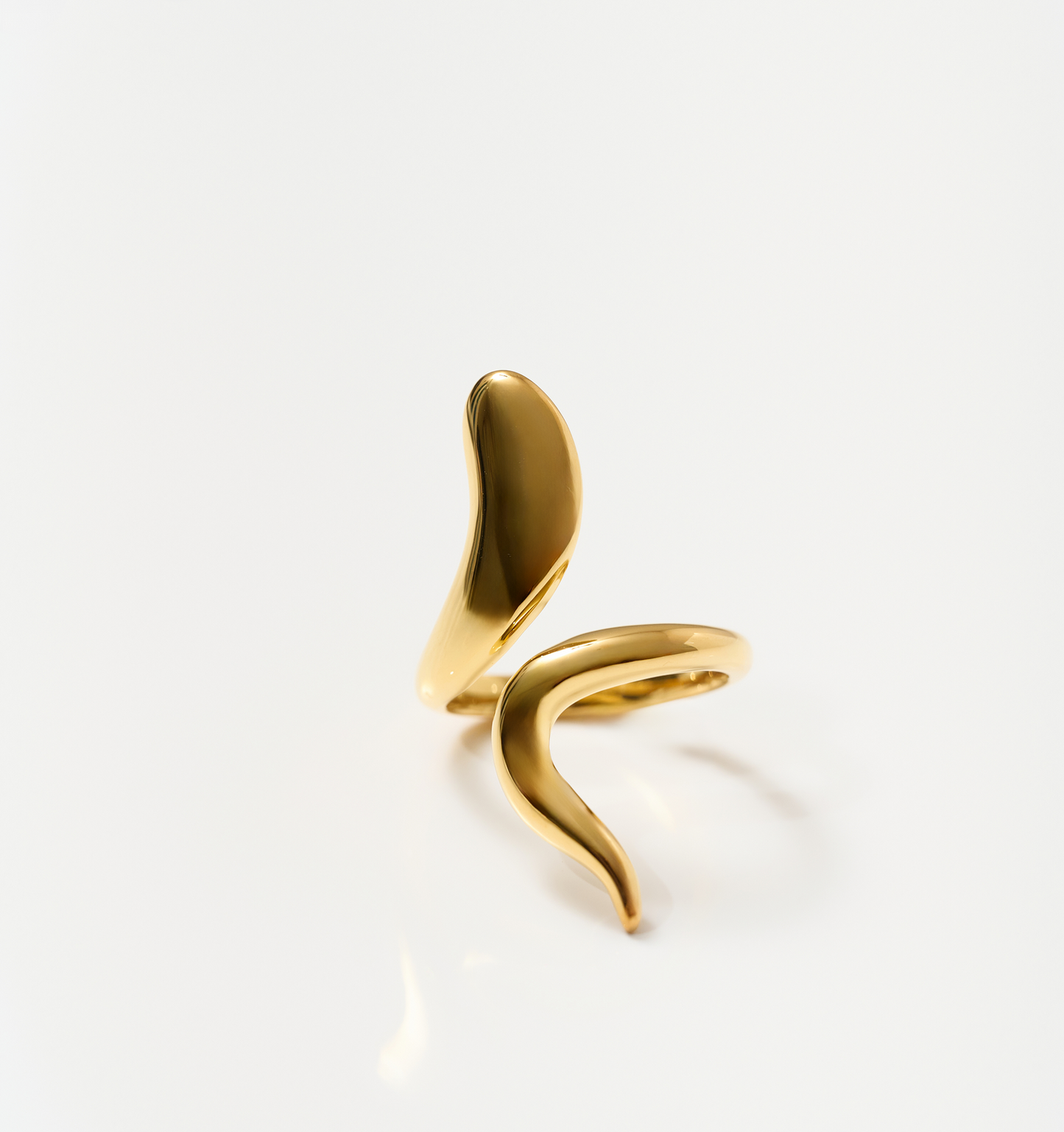 Minimalist luminous gold Saachi Ring with a bold, sweeping design symbolizing elegance and movement.