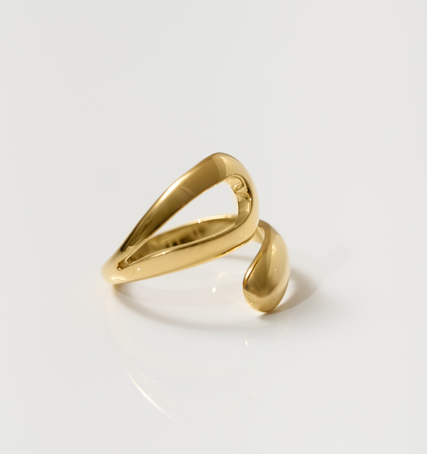 Elegant gold Oriya Ring with a smooth, inward spiral design on a white background