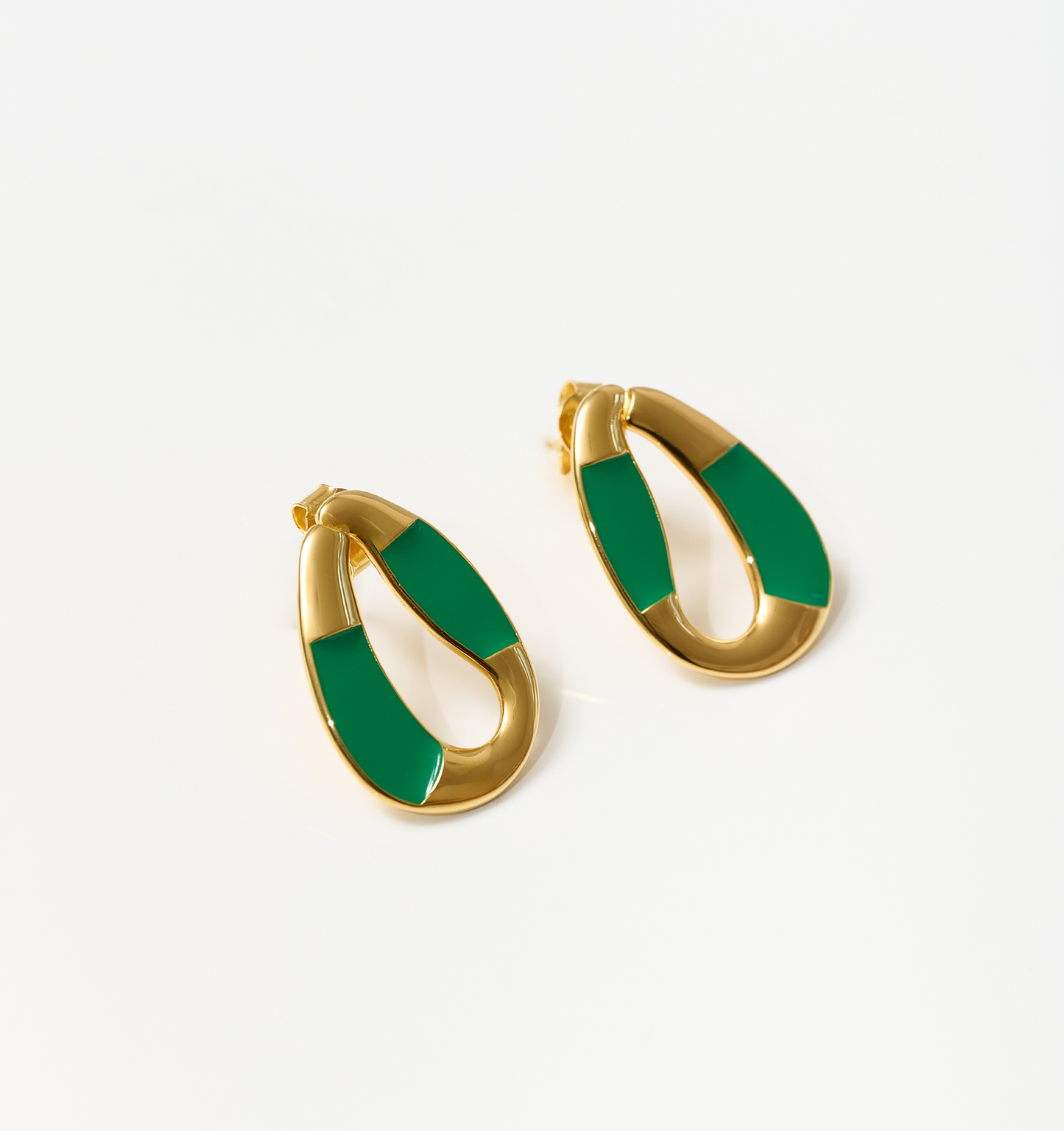 Vana Loop earrings with forest green enamel and sculpted gold design on white background
