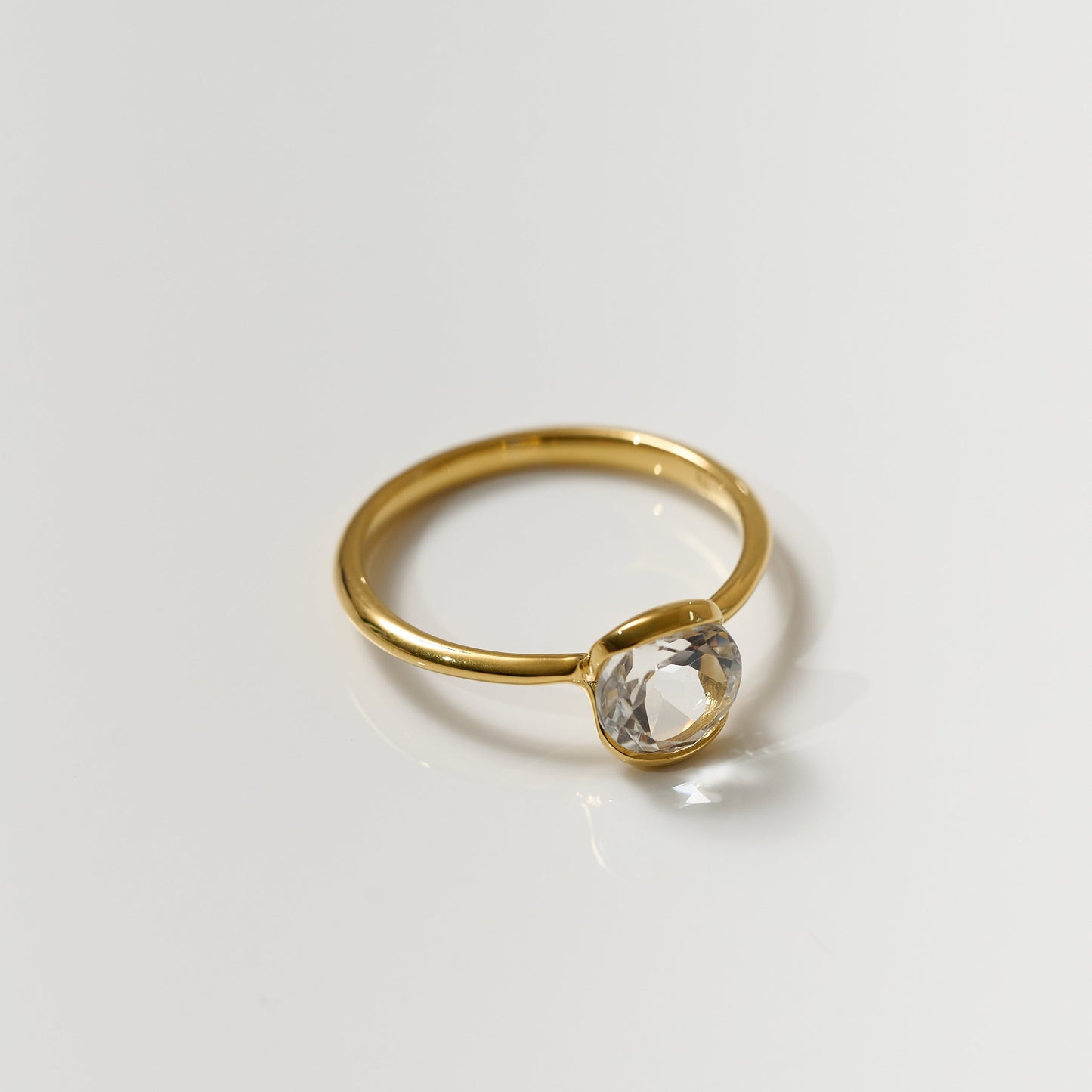 Ruhi Ring with delicate white topaz gemstone set in polished gold band reflecting clarity and elegance