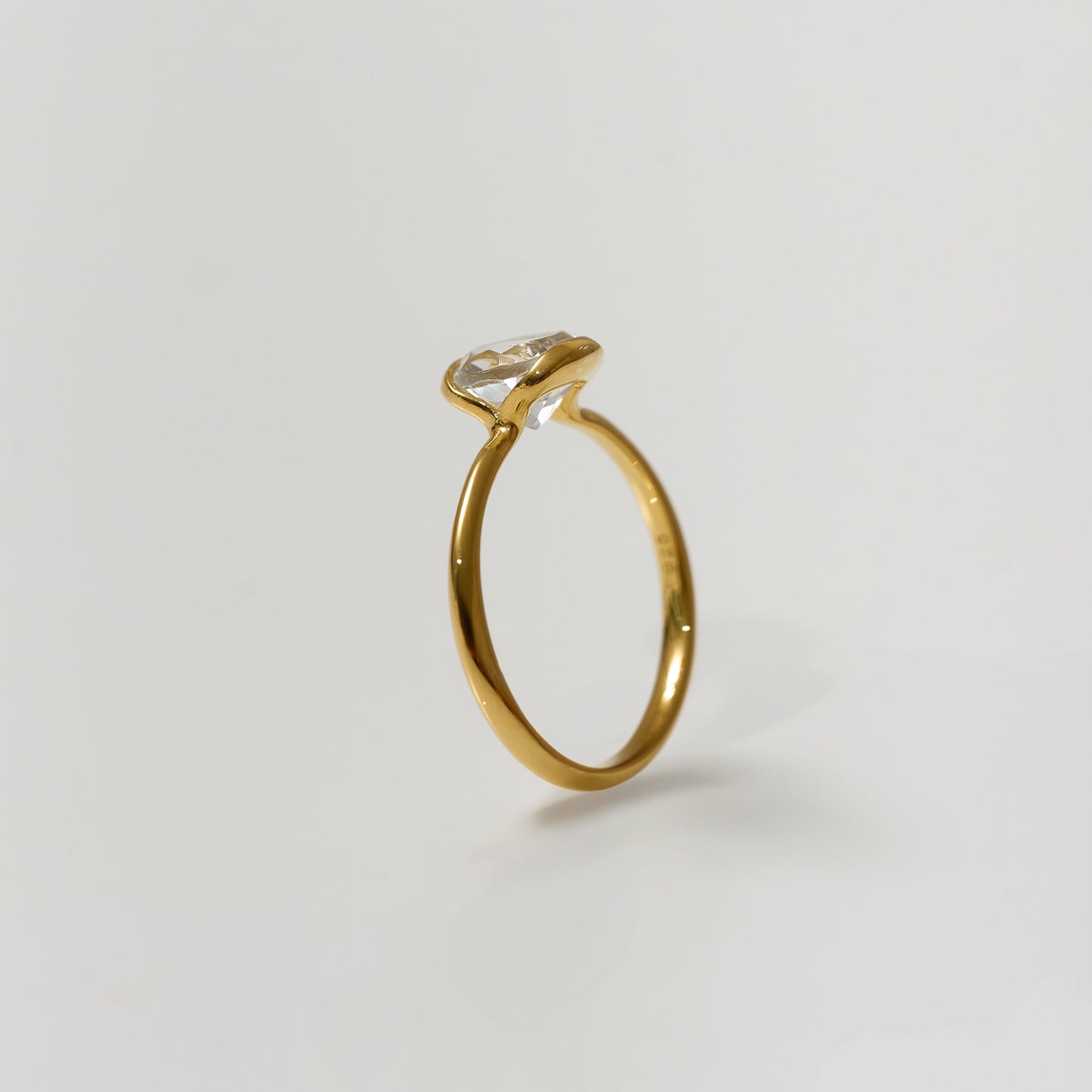 Ruhi Ring featuring delicately angled white topaz on a polished gold band reflecting light and clarity