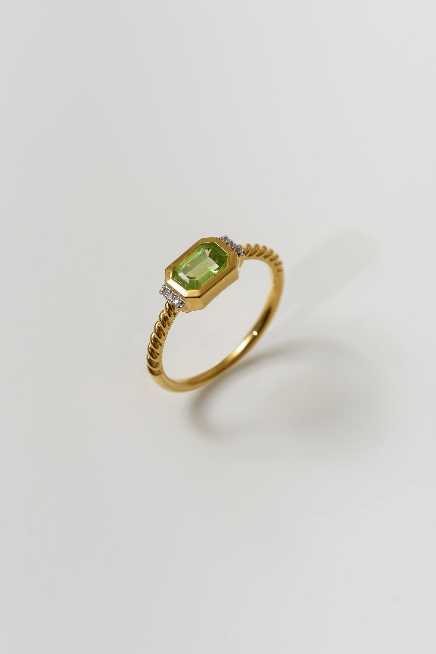 Gold Solae Ring with green peridot center stone and white topaz accents