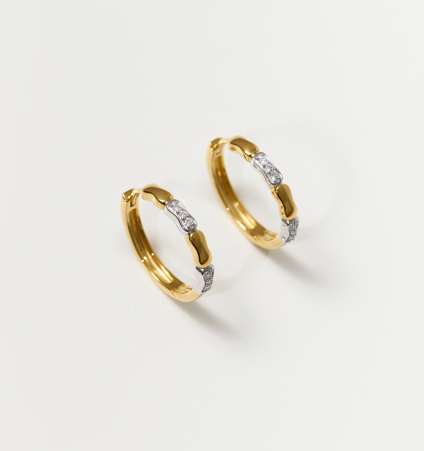Orita Earrings gold and silver hoop design with sparkling stones on white background