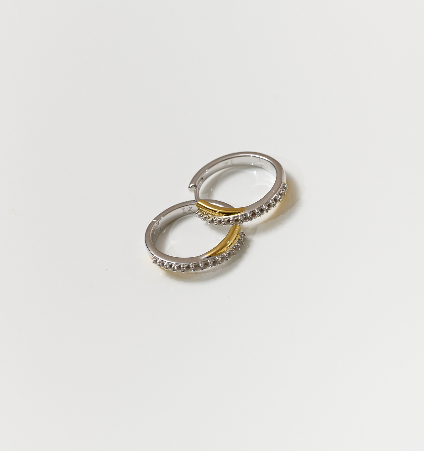 Silver and gold Mishri Hoops earrings with white topaz detailing on a white background