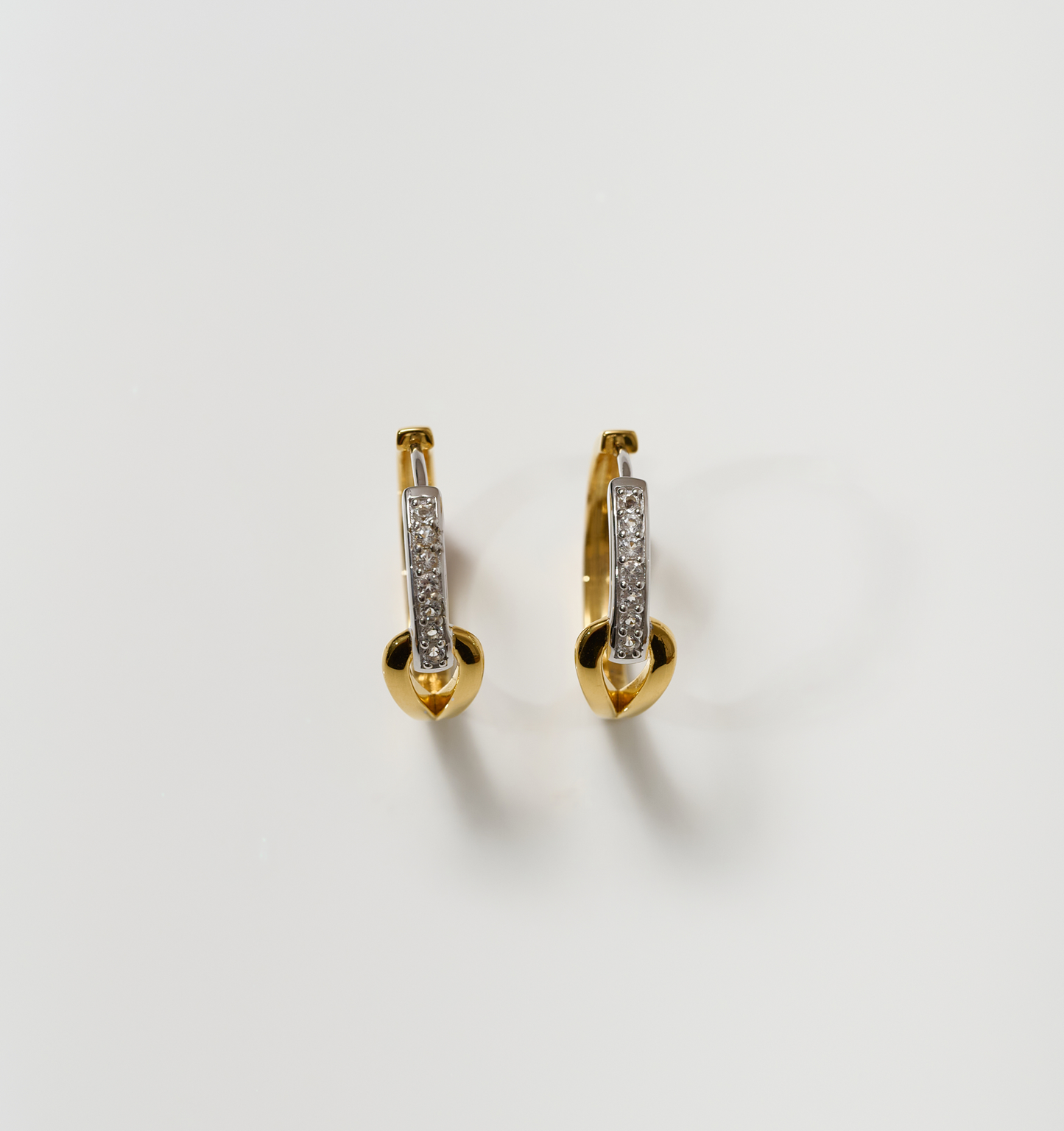 Ekatra Earrings featuring intertwined silver and gold with embedded stones on white background
