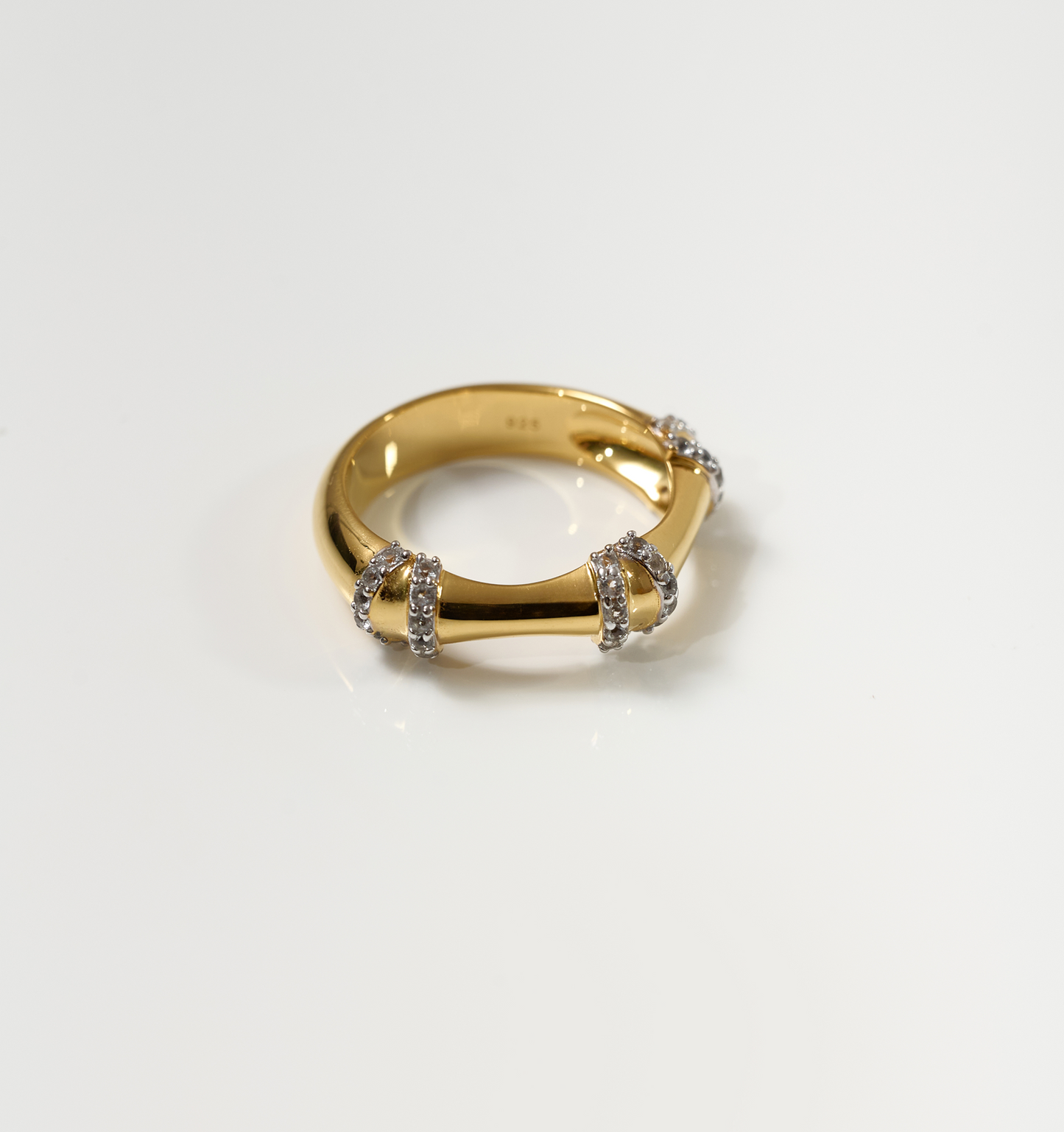 Ansh Ring gold band with three white topaz encrusted sides on white background