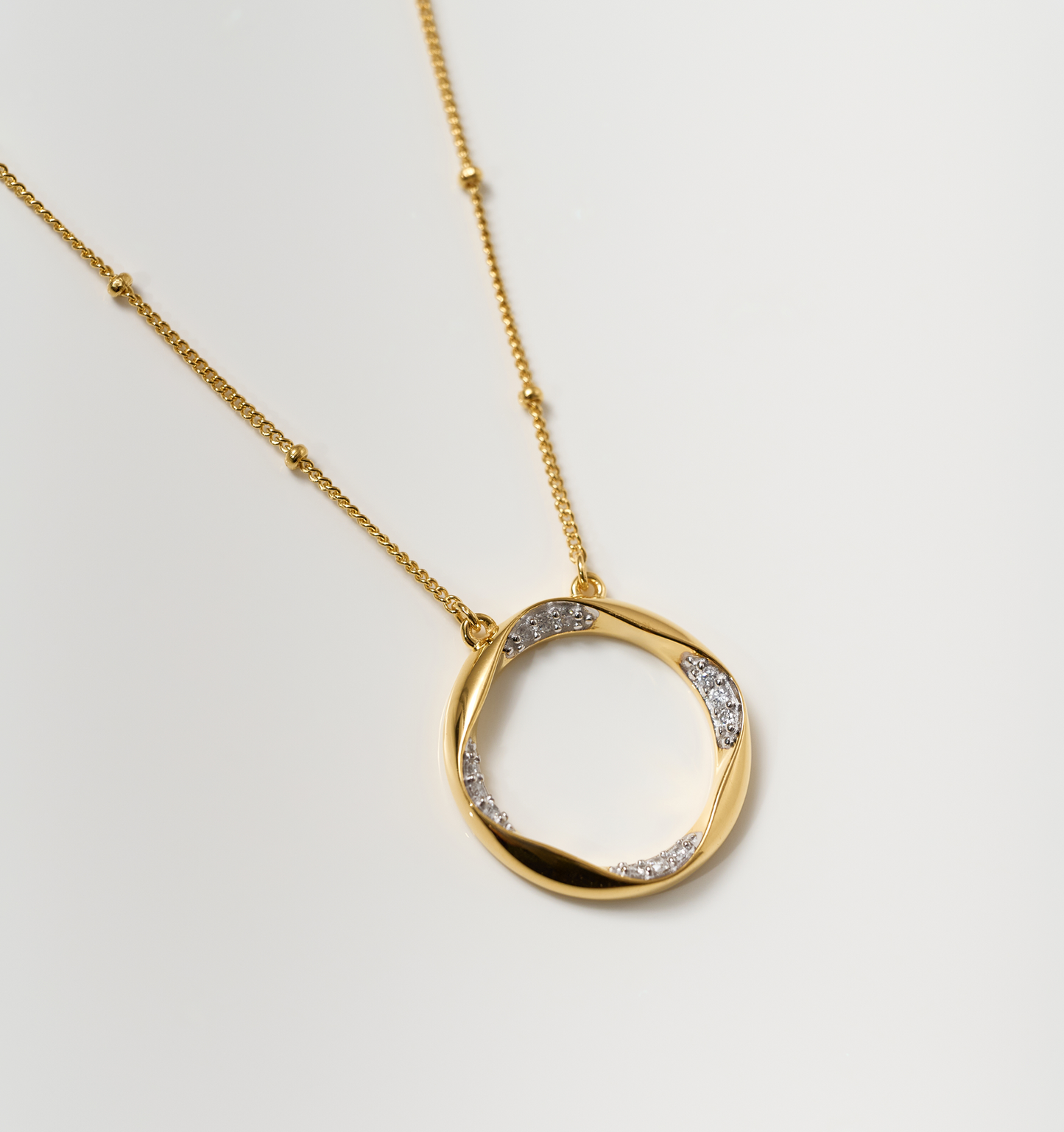 Taral Necklace elegant gold circle pendant with white topaz stones on delicate chain
