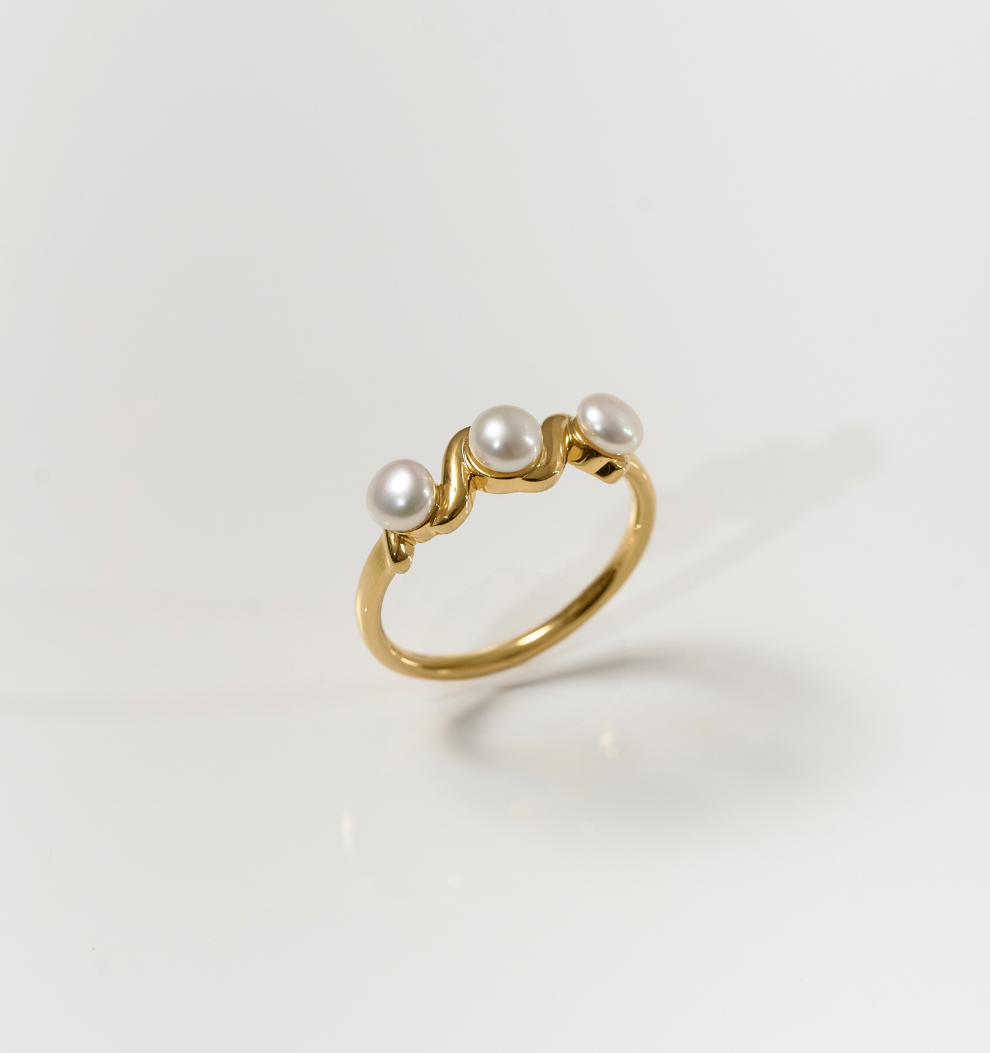 Tirya Ring elegant gold band with three pearls in a sculptural design
