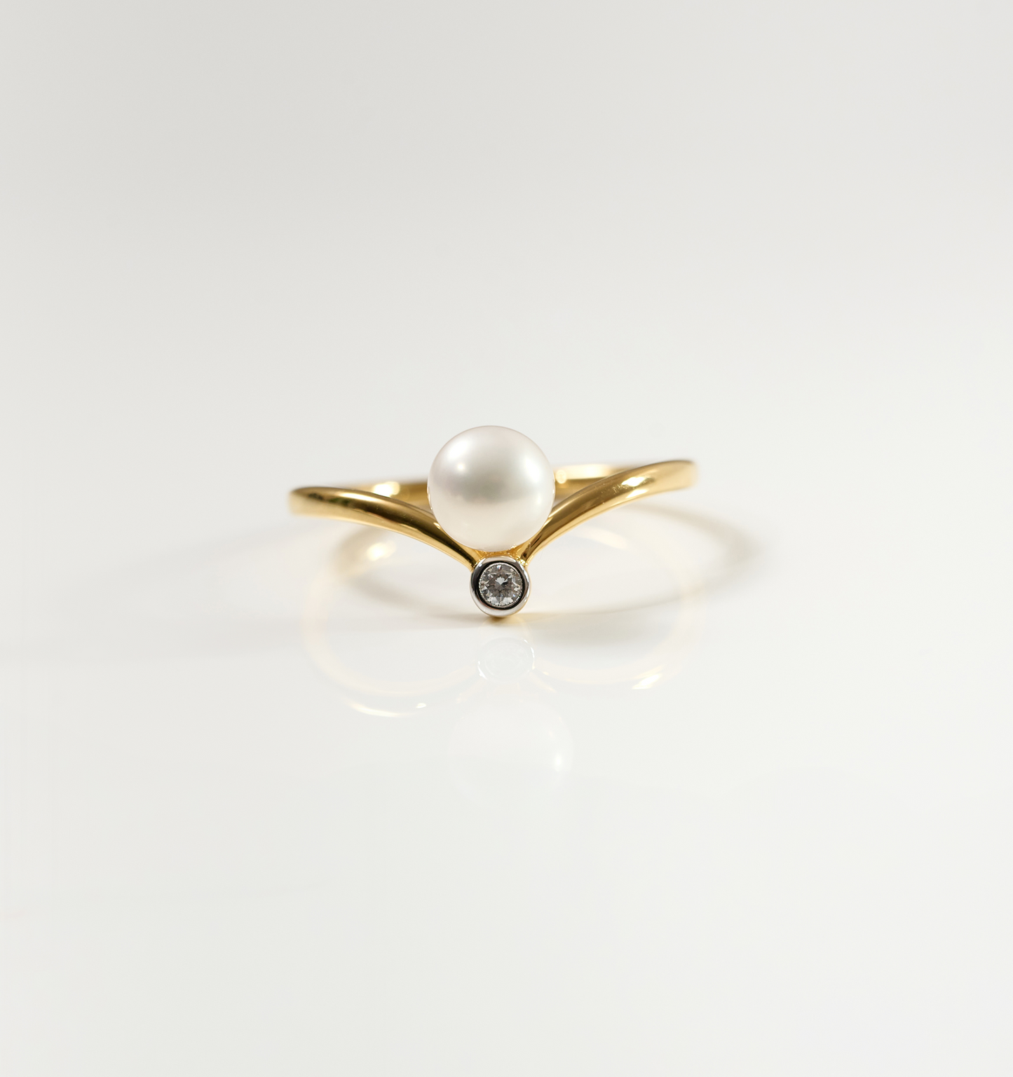 Sirna Ring with gold band, pearl centerpiece, and small star-shaped diamond detail