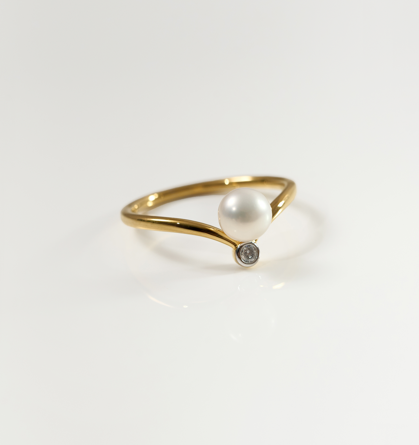 Sirna Ring gold band with pearl and small star diamond accent on white background