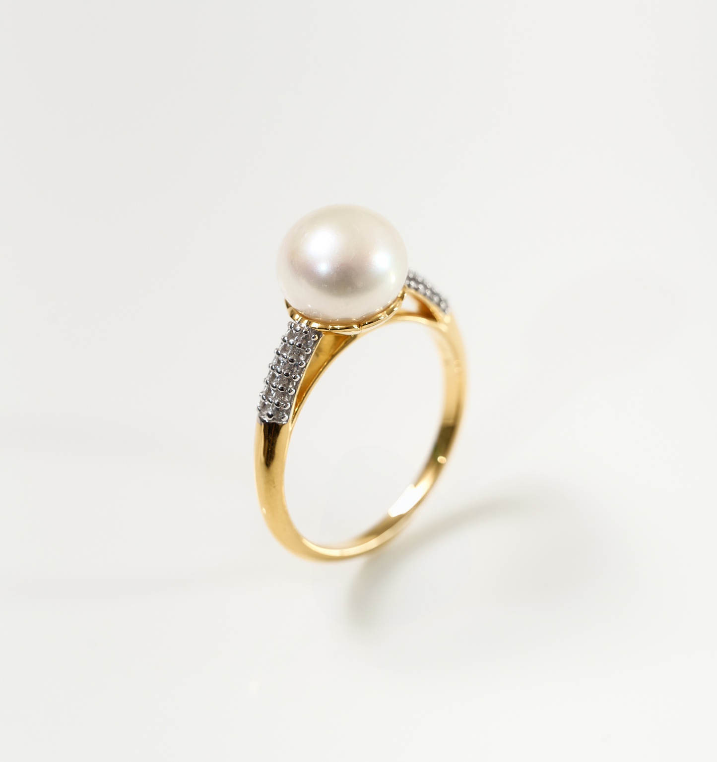 Sitara Ring featuring a luminous pearl with a halo of white topaz on a gold band