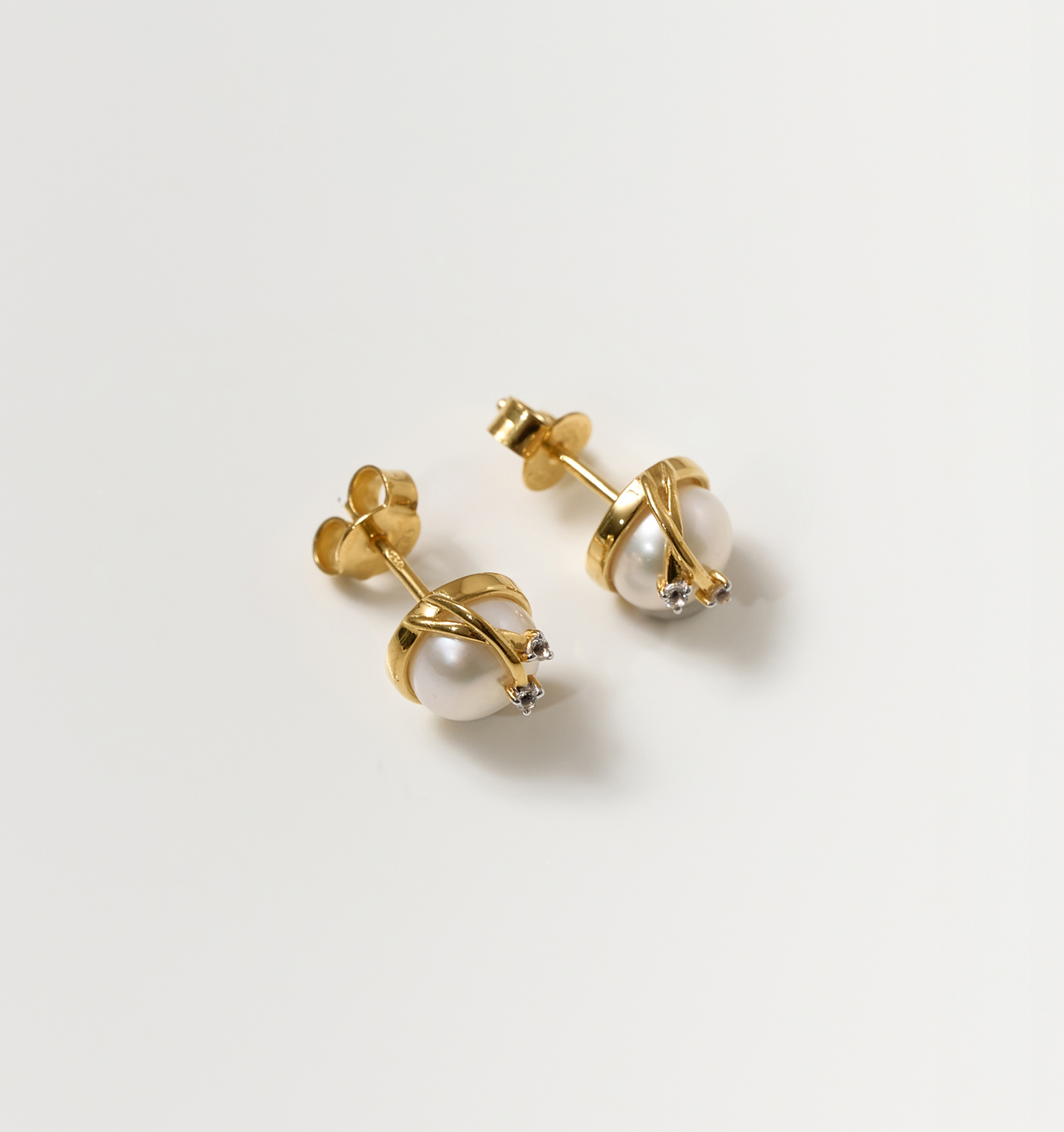 Poorna Earrings featuring gold settings with pearls and small star accents symbolizing completeness and grace.