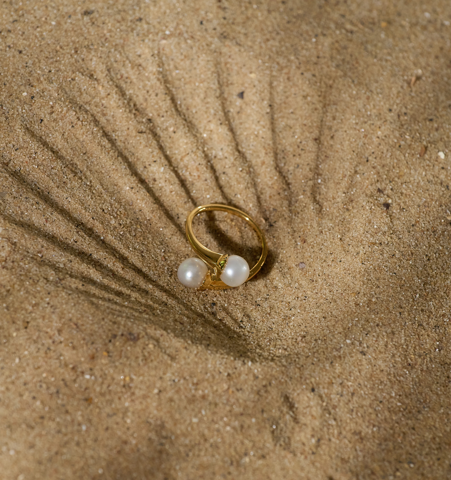 YugYagn Ring with two pearls on sandy textured background
