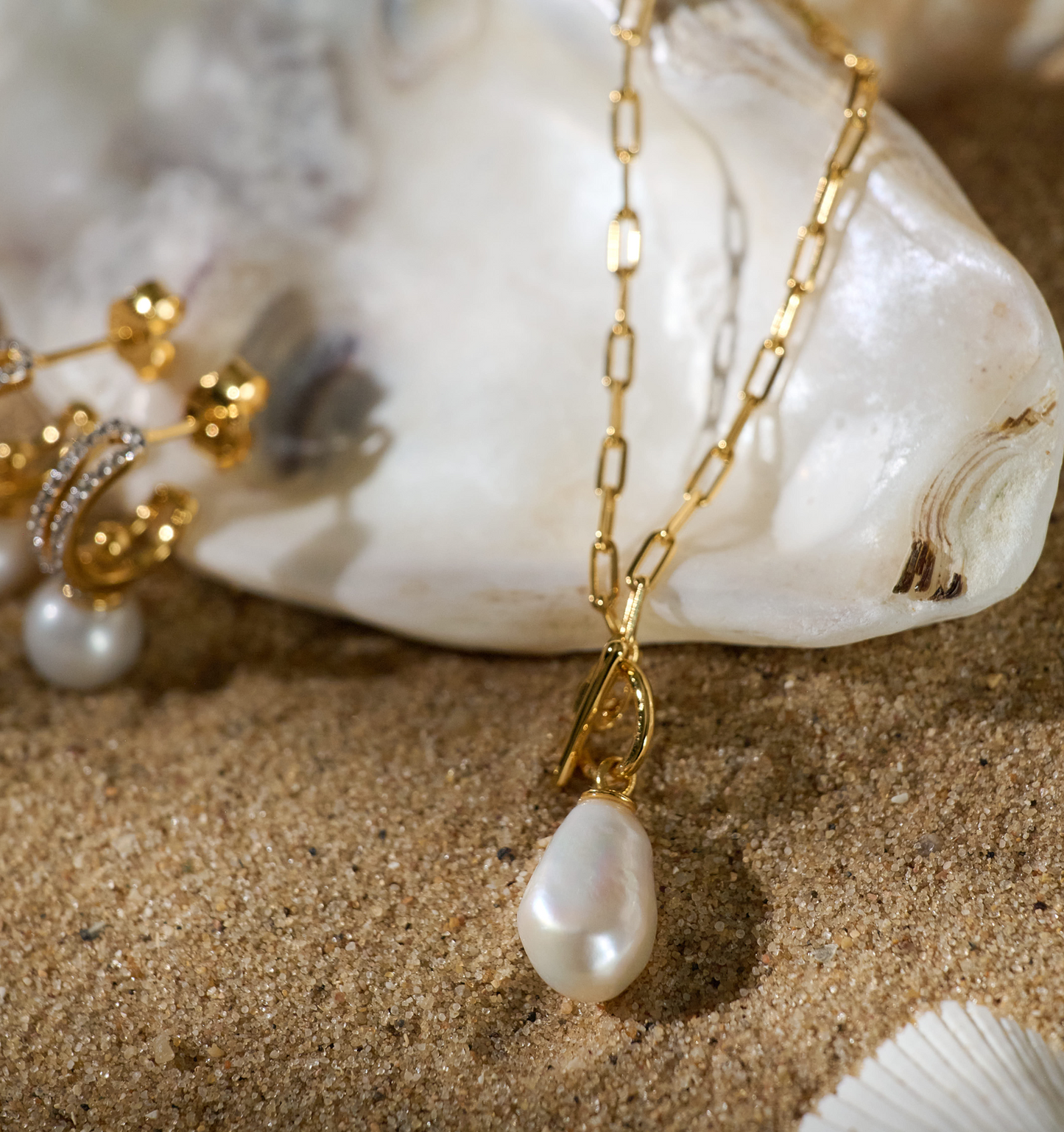 Rayi Necklace gold chain with single pearl pendant on sandy background