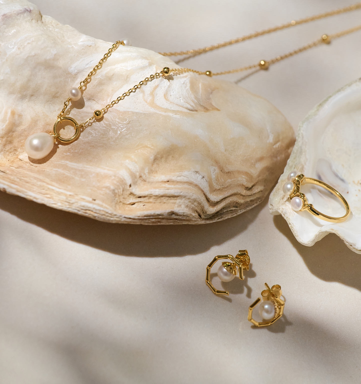 Kavach earrings and necklace set with pearl accents and gold bamboo-inspired design on seashells