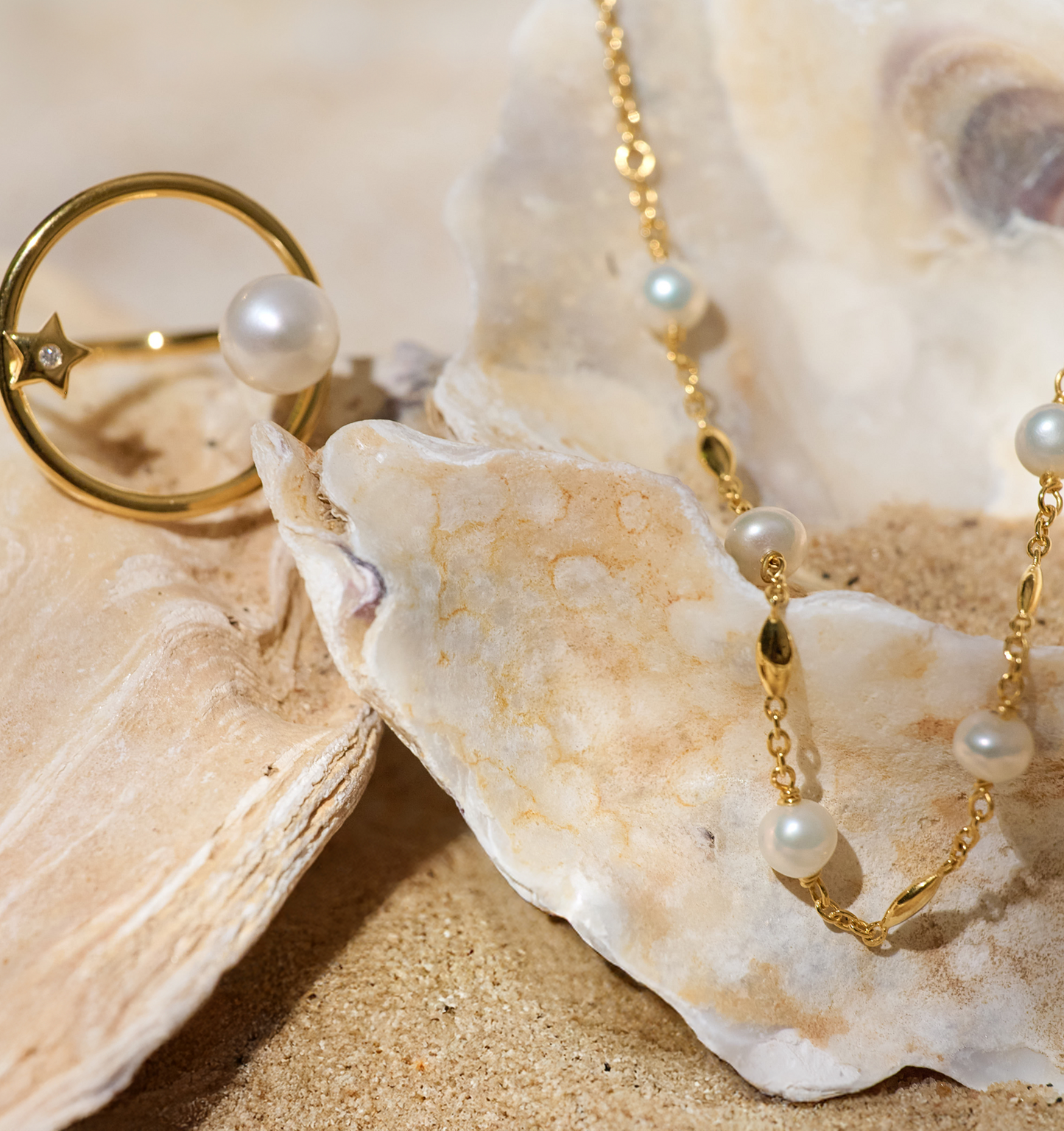 Manjari Necklace with five pearls and gold chain displayed on seashells