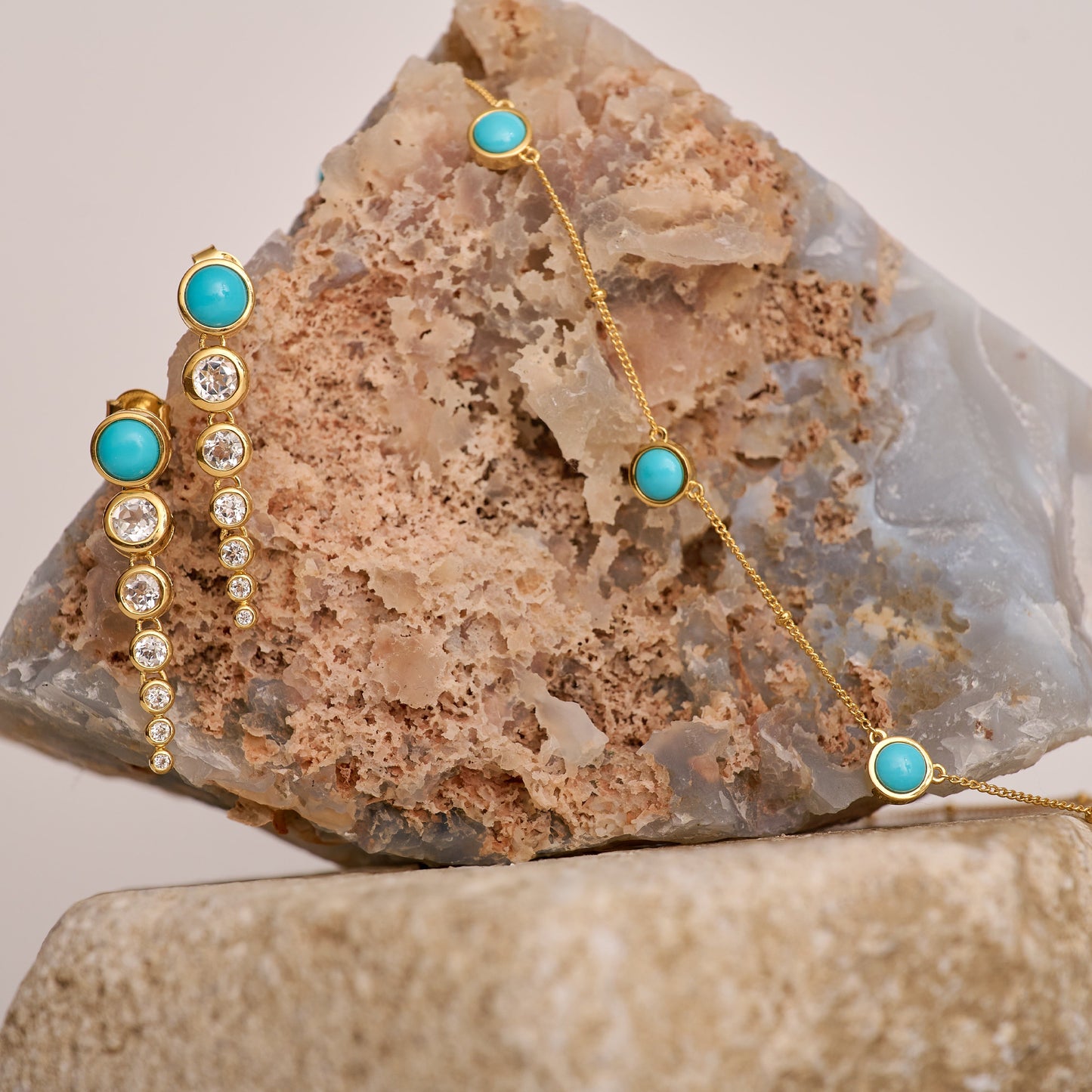 Vaani Necklace with turquoise stones and gold chain on natural stone background