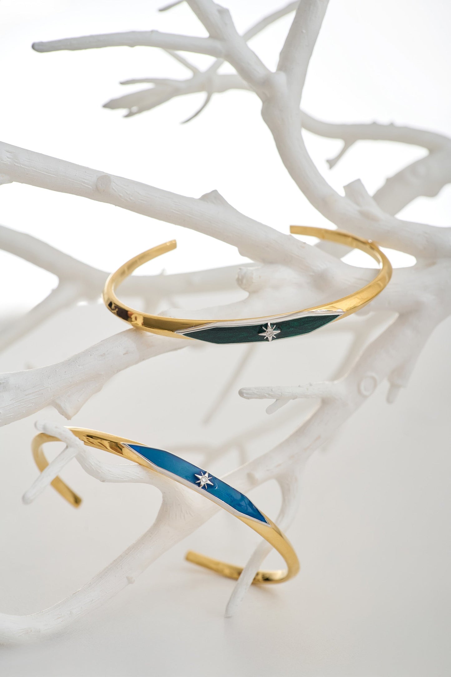 Naksha Cuff gold enamel bracelets with diamond accents on white branch display