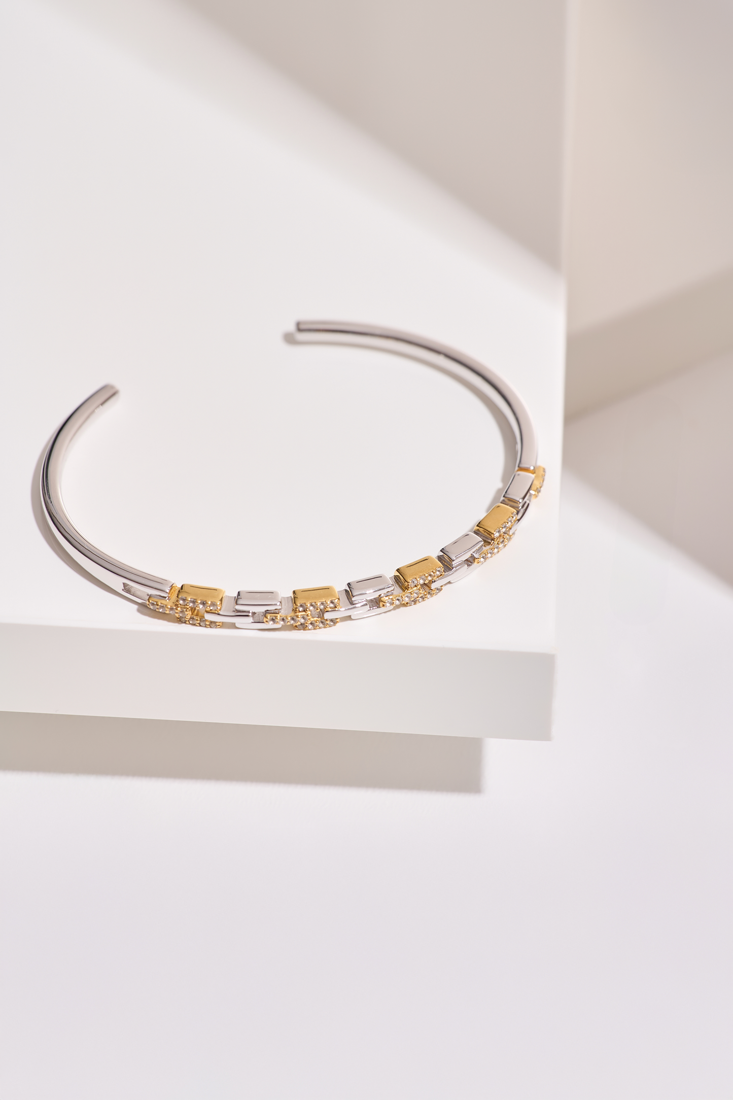 Noura Cuff gold and silver bracelet with 52 sparkling stones on a white surface