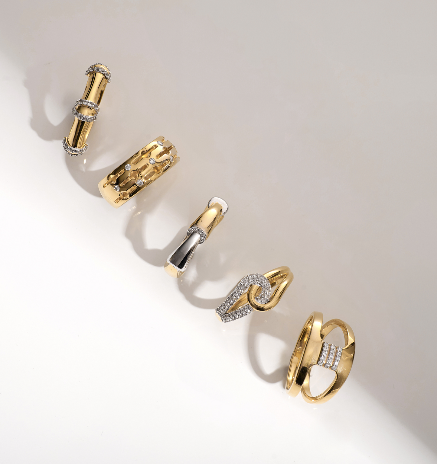 Collection of gold and white topaz rings including the Sahaya Ring with intertwined paths and knot design