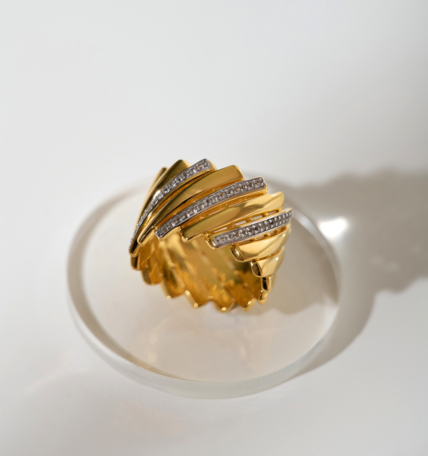 Gold Reya Ring with chevron curves and white topaz stones, elegant fluid design