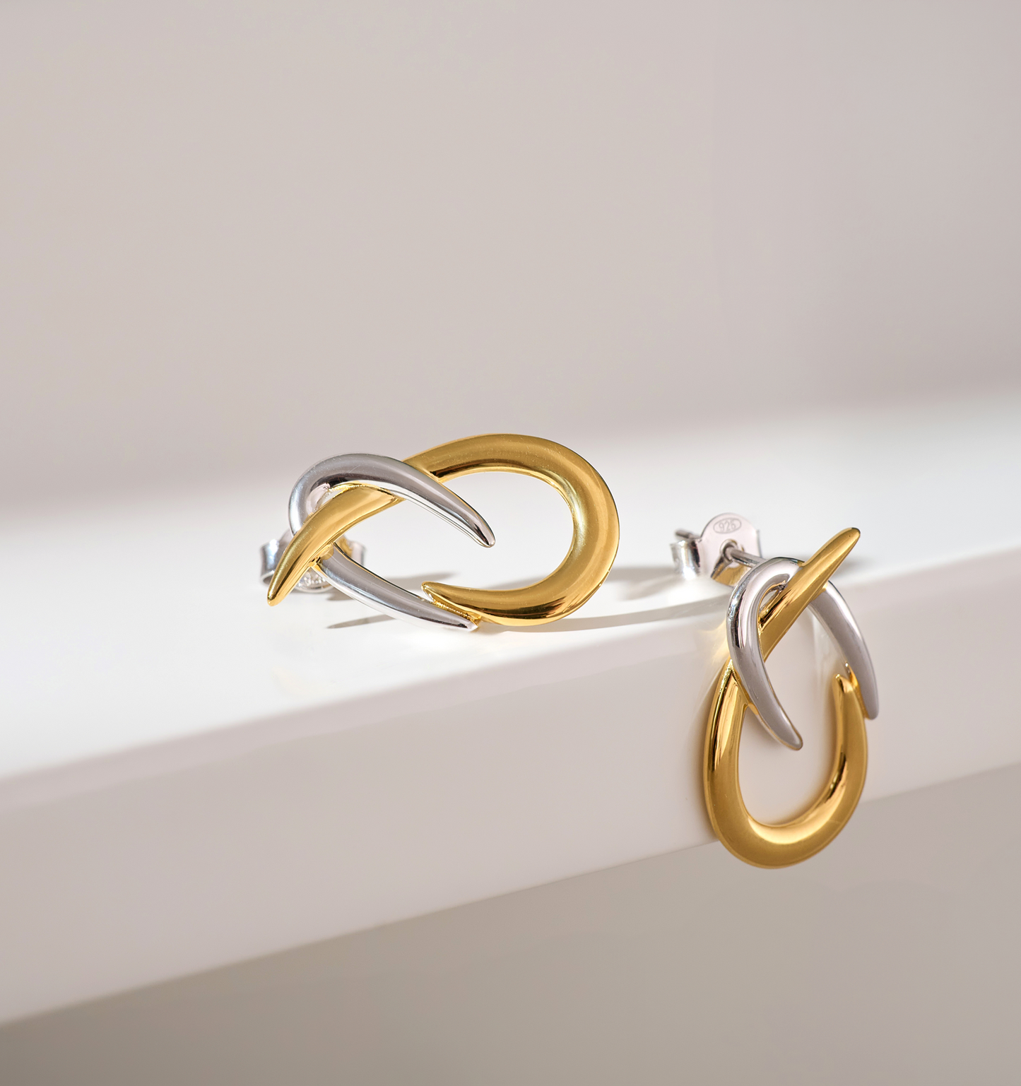 Syra Earrings gold and silver interlaced arcs minimalist bold design