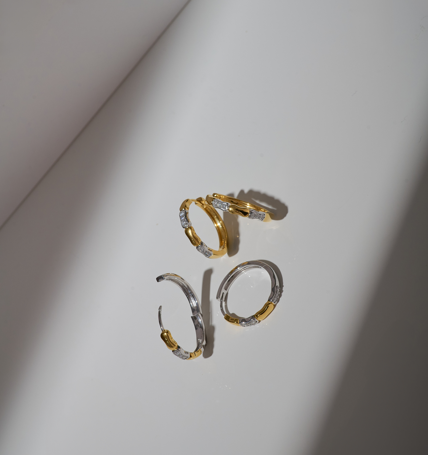 Orita Earrings gold and silver hoops with delicate stone accents on white background