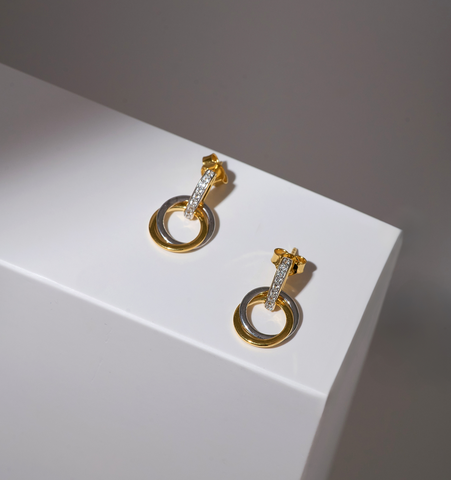 Nirya Earrings gold hoop design with diamond accents on white surface