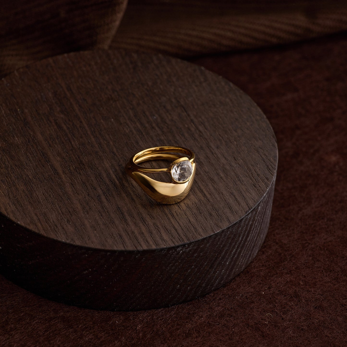 Gold Ruhi Ring with white topaz on dark wooden display block