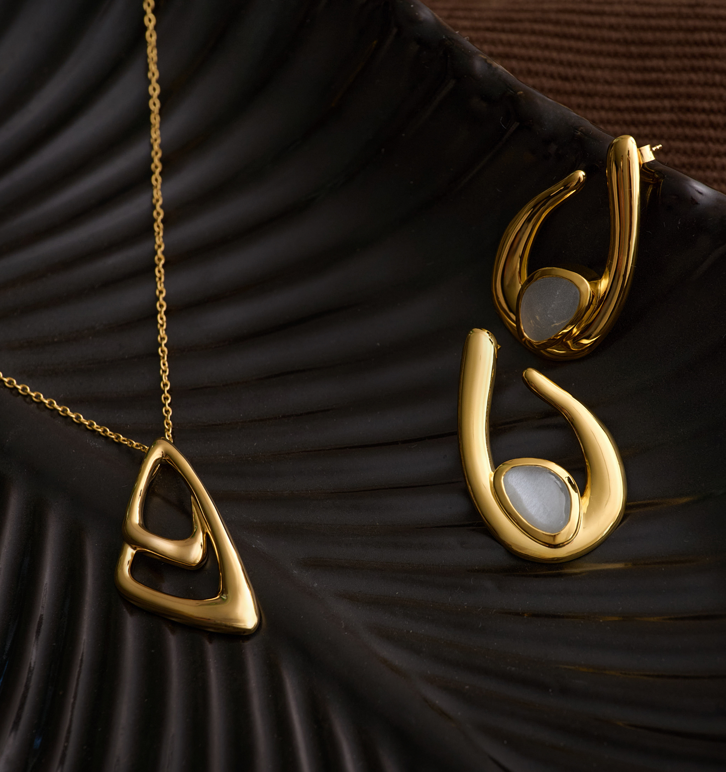 Aavrit Necklace gold geometric pendant on chain showcasing elegant curved design